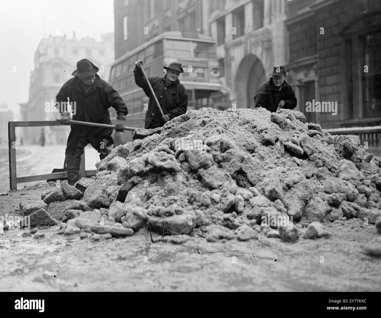 Westminster affronta la neve una grande campagna di sgombero della neve è stata avviata dal Westminster City Council. Hanno una flotta di autocarri che rimuovono la neve dalle strade fino ai canali di scolo strategicamente collocati , dove la neve viene ' scaricata '. Le strade principali vengono prima sgomberate quelle meno importanti verranno trattate in seguito, a meno che non si verifichi un disgelo. Spettacoli fotografici: I dipendenti del Westminster Council spalancano una "montagna" di neve in uno scarico nel centro commerciale Pall. 8 marzo 1947 Foto Stock