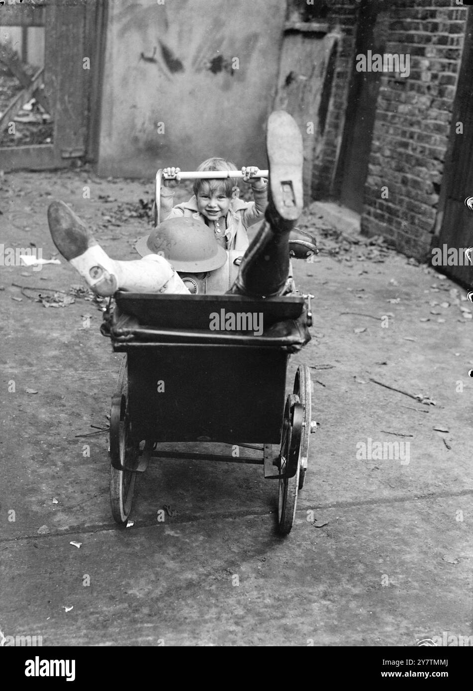 Il ragazzo trova una pila di leggiBrian Curtis , di dieci anni , con altri bambini che giocano vicino a un sito bombardato in Granville Road , Kilburn , Londra ha trovato una pila di arti smembrati - ma fortunatamente erano artificiali - tra i detriti . Brian ha detto di aver trovato più di una dozzina di zampe - alcune con stivali e calzini a tutta lunghezza , legate in cima . Con loro c'erano una serie di maschere antigas. Uno dei bambini disse: »Un uomo li ha scaricati vicino al sito della bomba e ci ha detto di non toccarli». Foto: Bambini che giocano con gli arti artificiali e le maschere antigas sul sito bombardato a Granville Road, Kilbur Foto Stock