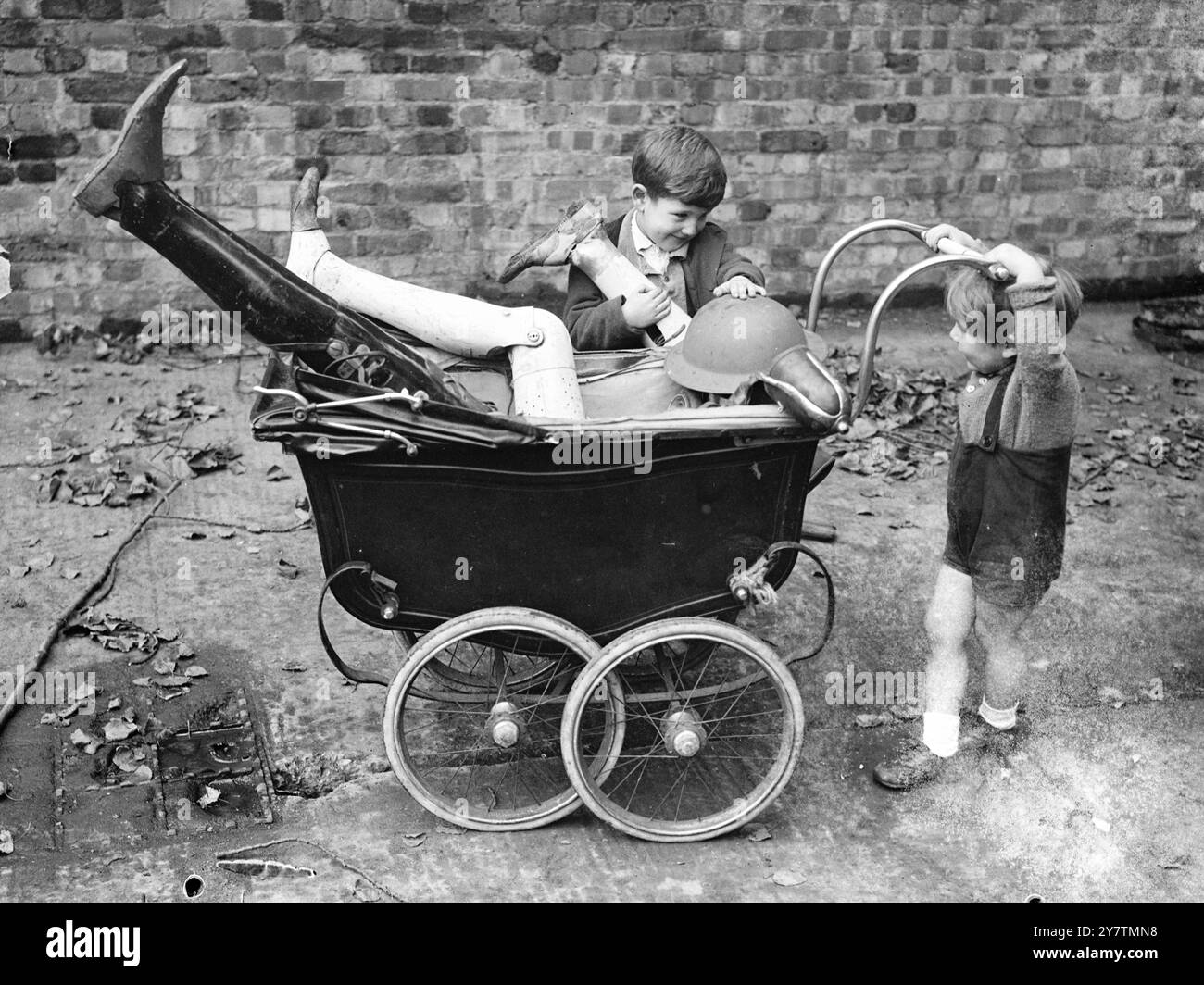 Il ragazzo trova una pila di leggiBrian Curtis , di dieci anni , con altri bambini che giocano vicino a un sito bombardato in Granville Road , Kilburn , Londra ha trovato una pila di arti smembrati - ma fortunatamente erano artificiali - tra i detriti . Brian ha detto di aver trovato più di una dozzina di zampe - alcune con stivali e calzini a tutta lunghezza , legate in cima . Con loro c'erano una serie di maschere antigas. Uno dei bambini disse: »Un uomo li ha scaricati vicino al sito della bomba e ci ha detto di non toccarli». Foto: Bambini che giocano con gli arti artificiali e le maschere antigas sul sito bombardato a Granville Road, Kilbur Foto Stock