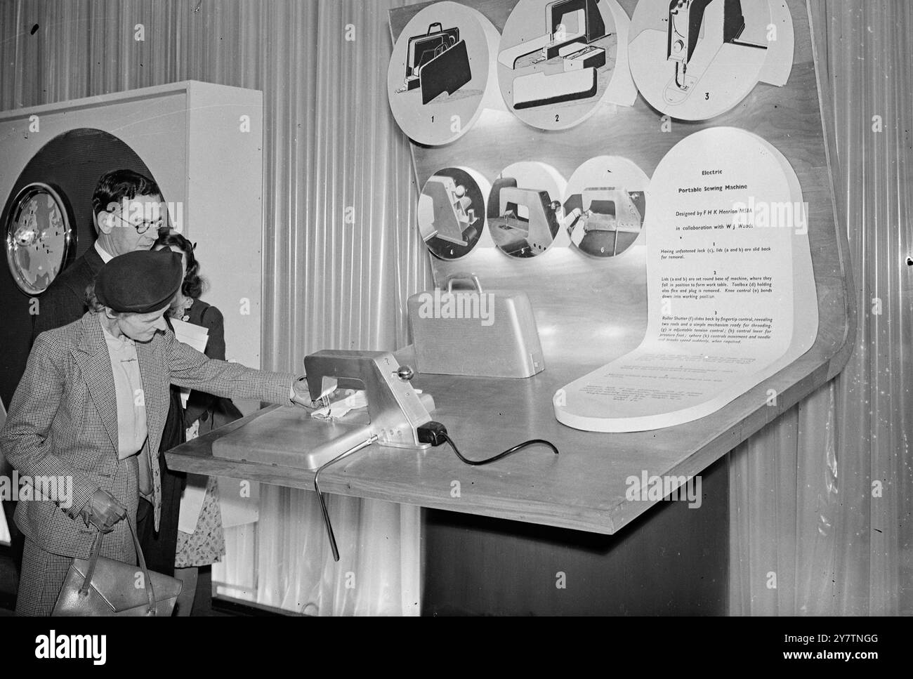 Macchina da cucire portatile alla mostra ' Britain CAN Make IT' le ultime idee prodotte dall'industria britannica sono in mostra alla Britain CAN Make IT Exhbition che verrà aperta da Re Giorgio vi al Victoria and Albert Museum di Londra. Scopo della mostra è mostrare la varietà e la qualità dei prodotti britannici. In mostra ci sono quasi 6.000 esposizioni di oltre 1.300 aziende. Includono il lavoro di circa 400 singoli designer. La foto mostra: Ispezione di un macchinario da cucire elettrico portatile estremamente compatto. La leva di alimentazione è azionata da ginocchio; una luce splende sull'ago. La custodia da trasporto Foto Stock