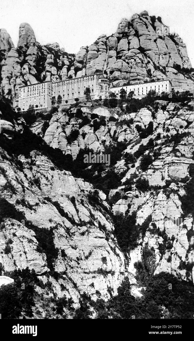 IL MONASTERO SULLA MONTAGNA SACRA È il PIÙ GRANDE SANTUARIO DELLA SPAGNA e mostra foto: Il Monastero sulla sua piattaforma rocciosa visto dalla Grotta della Vergine. 30 km circa da Barcellona si trova il monastero benedettino di Montserrat. Il monastero risale al IX secolo e la sua fondazione è associata alla celebrata Vergine Nera (la Morenata) nella chiesa del monastero. 1946 Foto Stock