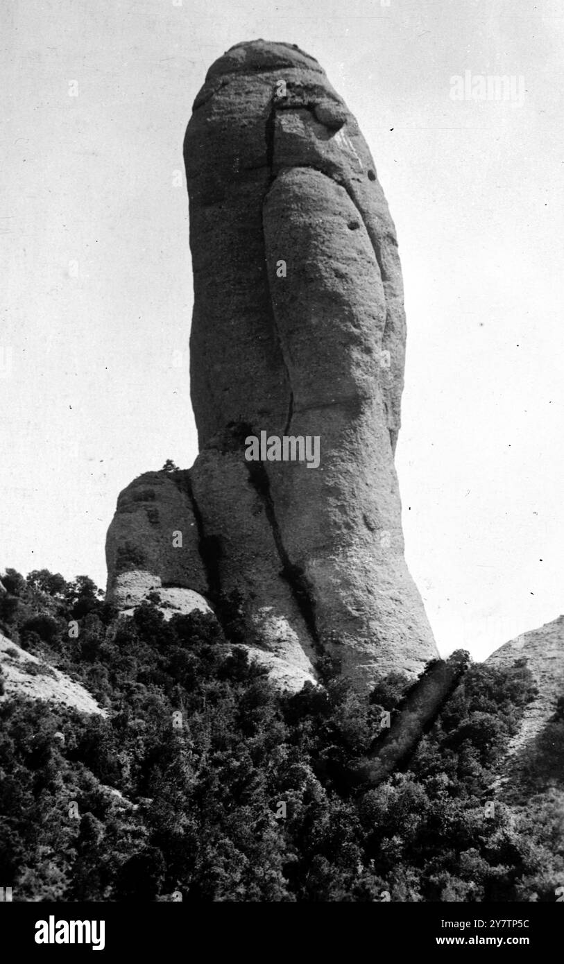 IL MONASTERO SULLA MONTAGNA SACRA È il PIÙ GRANDE SANTUARIO DELLA SPAGNA e mostra foto: Una roccia che si erge come una sentinella sopra il monastero. 30 km circa da Barcellona si trova il monastero benedettino di Montserrat . Il monastero risale al IX secolo e la sua fondazione è associata alla celebrata Vergine Nera (la Morenata) nella chiesa del monastero. 1946 Foto Stock