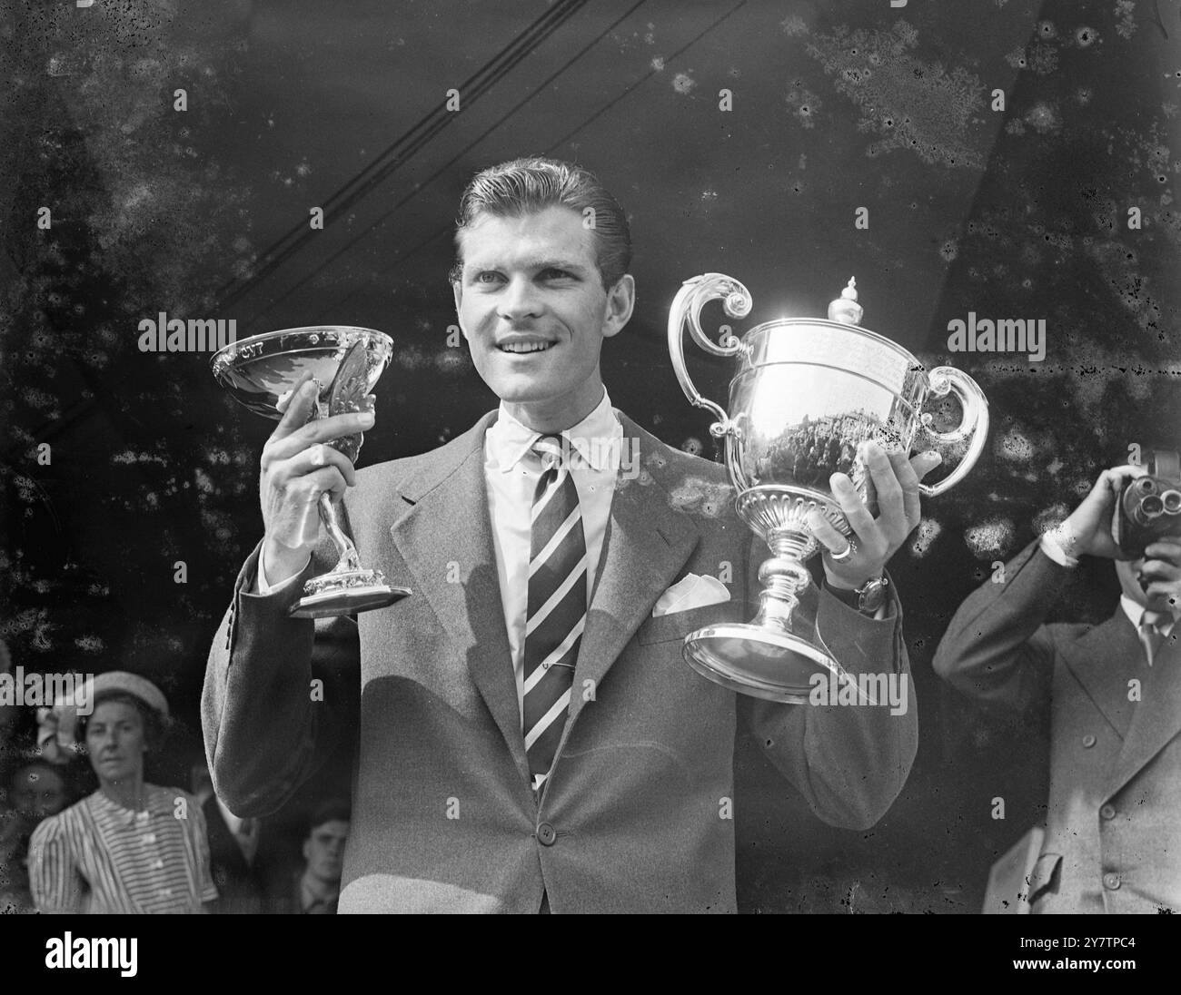 L'America's Budge Patty detiene in alto la Challenge Cup (a destra) e la Renshaw Cup, presentata annualmente per il vincitore maschile da e e W Renshaw, dopo la sua vittoria contro l'australiano Frank Sedgman nella finale maschile dei Campionati di tennis sul prato di Wimbledon. Ha vinto la sua battaglia di Centre Court contro gli australiani per 6-1, 8-10, 6-2, 6-3. Budge restituirà la Challenge Cup - mantiene una replica - ma mantiene la Renshaw Cup. La principessa Alice, contessa di Athlone, ha eseguito la presentazione al Centre Court Royal Box. 7 luglio 1950 Foto Stock