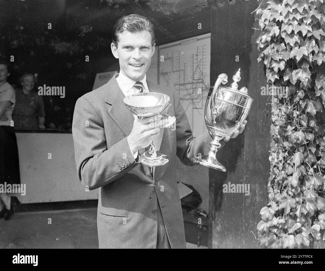 L'America's Budge Patty detiene in alto la Challenge Cup (a destra) e la Renshaw Cup, presentata annualmente per il vincitore maschile da e e W Renshaw, dopo la sua vittoria contro l'australiano Frank Sedgman nella finale maschile dei Campionati di tennis sul prato di Wimbledon. Ha vinto la sua battaglia di Centre Court contro gli australiani per 6-1, 8-10, 6-2, 6-3. Budge restituirà la Challenge Cup - mantiene una replica - ma mantiene la Renshaw Cup. La principessa Alice, contessa di Athlone, ha eseguito la presentazione al Centre Court Royal Box. 7 luglio 1950 Foto Stock
