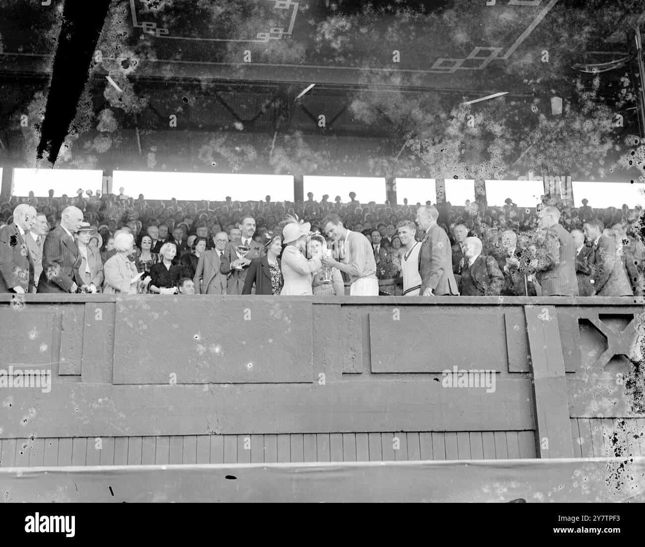 L'America's Budge Patty detiene in alto la Challenge Cup (a destra) e la Renshaw Cup, presentata annualmente per il vincitore maschile da e e W Renshaw, dopo la sua vittoria contro l'australiano Frank Sedgman nella finale maschile dei Campionati di tennis sul prato di Wimbledon. Ha vinto la sua battaglia di Centre Court contro gli australiani per 6-1, 8-10, 6-2, 6-3. Budge restituirà la Challenge Cup - mantiene una replica - ma mantiene la Renshaw Cup. La principessa Alice, contessa di Athlone, ha eseguito la presentazione al Centre Court Royal Box. 7 luglio 1950 Foto Stock