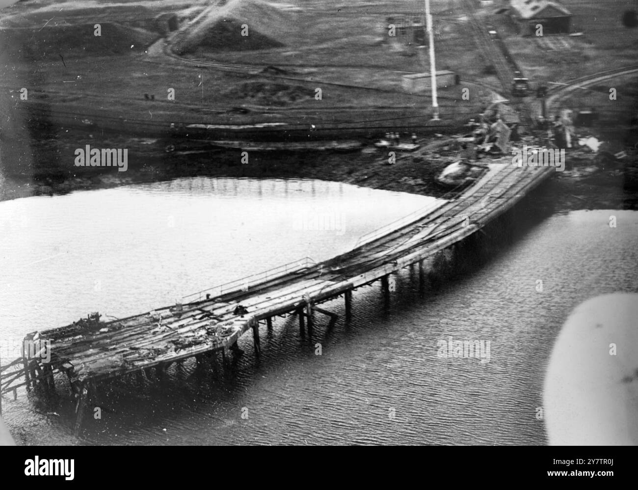 L'ESPLOSIONE DI PORTSMOUTH DISTRUGGE IL MOLO DELLE MUNIZIONI - TRENO GETTATO IN ACQUA. Un'immagine aerea della fine del molo, gravemente danneggiata dall'esplosione di 1400 tonnellate di proiettili e bombe nel deposito di munizioni della Royal Naval a Bedenham. I binari attorcigliati potrebbero sporgere dall'estremità del molo. Un treno di munizioni è caduto in acqua. Le esplosioni avvennero in alcune chiatte di munizioni navali, otto delle quali furono perse. La seconda esplosione e' stata sul treno delle munizioni sul molo. La maggior parte dei camion sono stati trasportati in sicurezza, ma quelli che sono esplosi hanno distrutto tutta la fine di Foto Stock