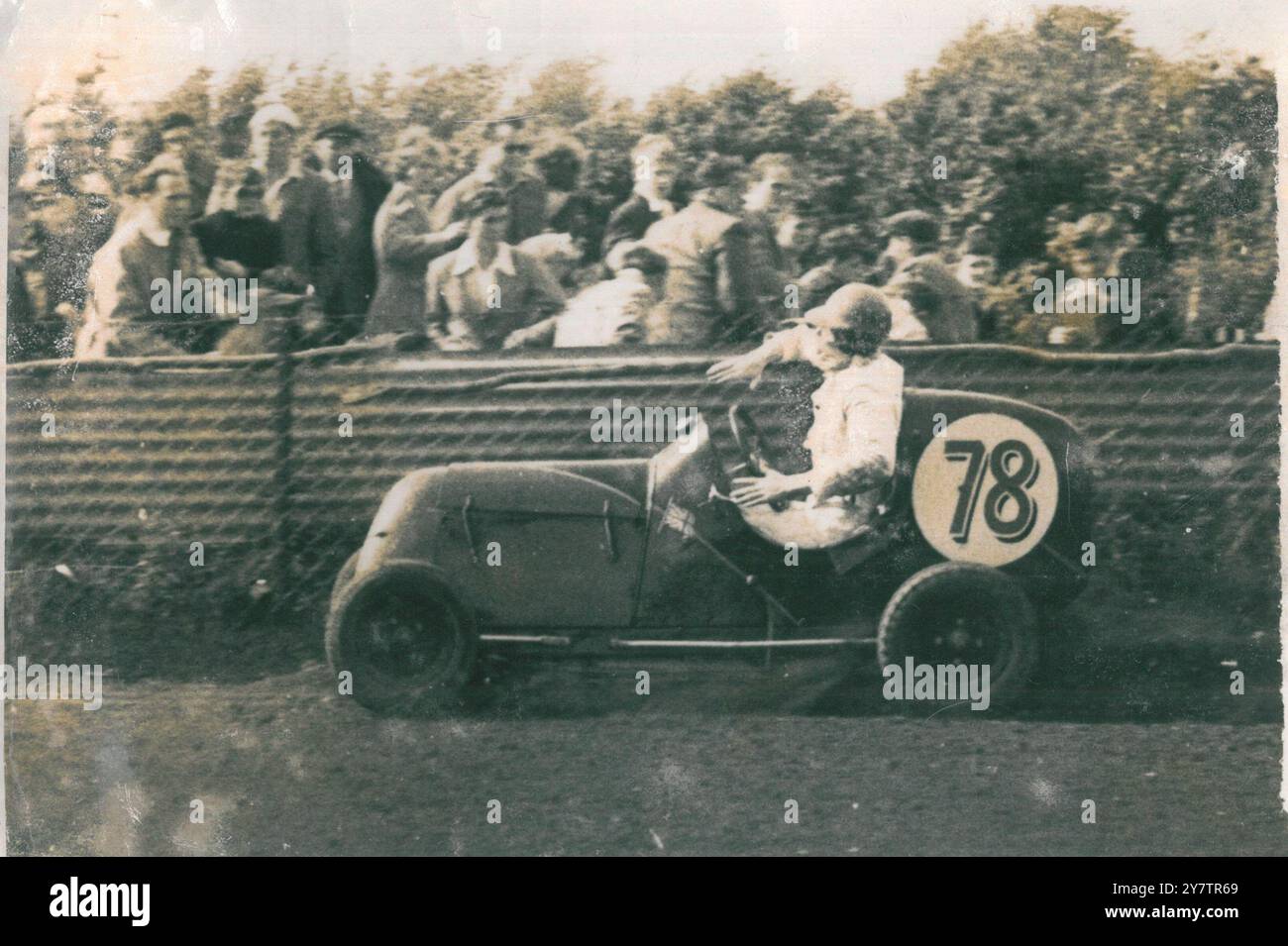 Gli spettatori si arrampicano mentre Larry Robinson rimbalza fuori dalla recinzione di sicurezza con la sua potente auto da corsa da 1000 cc, durante il Silver Helmet Championship che ha corso sull'Eastbourne Speedtrack, Sussex, Inghilterra. Robinson è caduto a metà dalla sua auto, ma in qualche modo ha tormentato indietro, ha riacquistato il suo sedile .... e ha vinto il suo caldo. 18 luglio 1950 Foto Stock