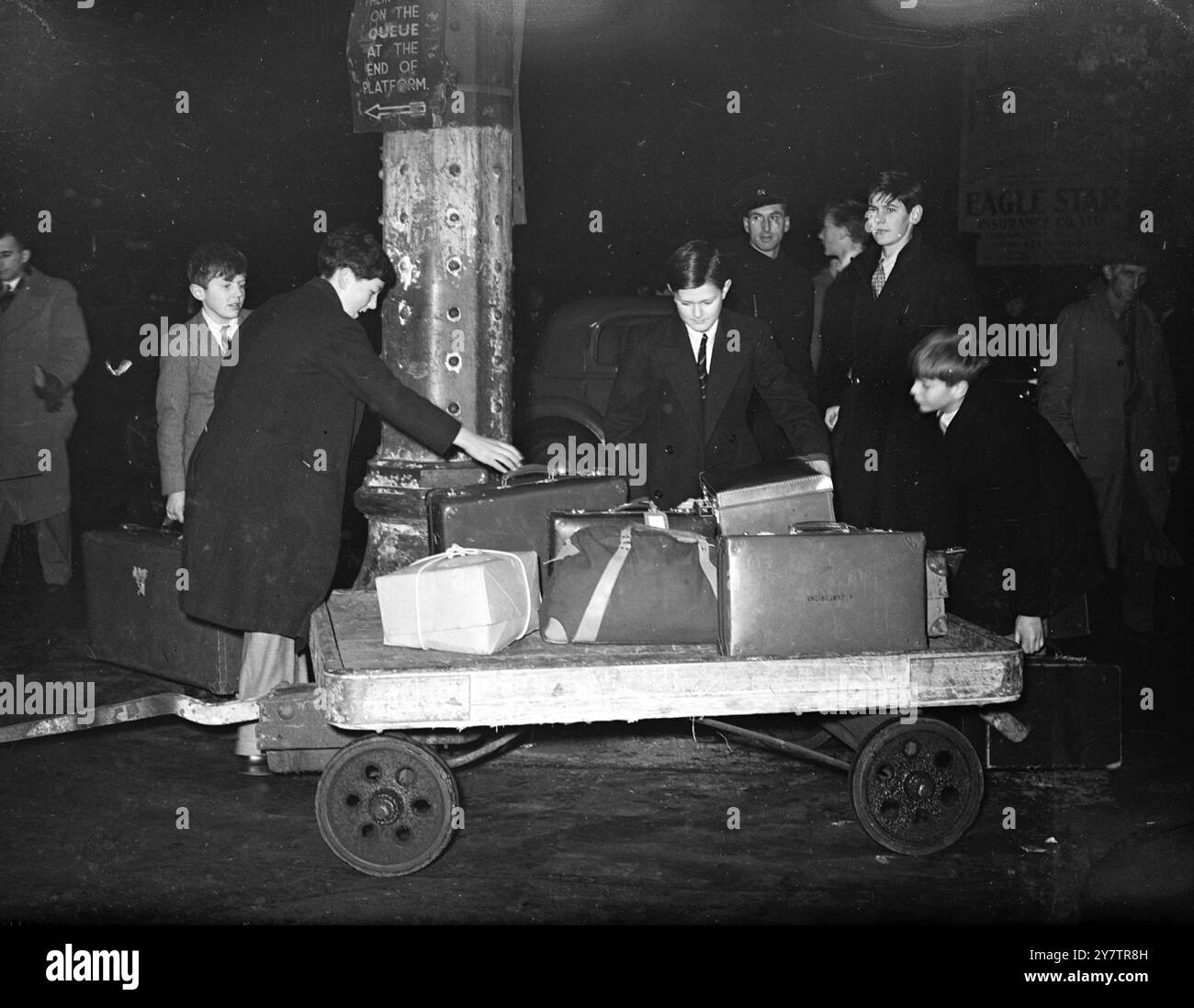 I RAGAZZI DI ETON TORNANO A CASA PER LE VACANZE DI NATALE Un treno speciale della mattina presto porta i ragazzi di Eton a Paddington Station, Londra, mentre la scuola si rompe per le vacanze di Natale. I ragazzi gestiscono i loro bagagli mentre cambiano treno nella stazione affollata. Ragazzi e ragazze di quasi 100 scuole arrivano lì con treni ordinari e speciali, al culmine della corsa. Foto Shwos: I ragazzi di Eton arrivano alla stazione di Paddington, Londra, portando con sé i loro bagagli, che partono per le vacanze di Natale. 19 dicembre 1945 Foto Stock