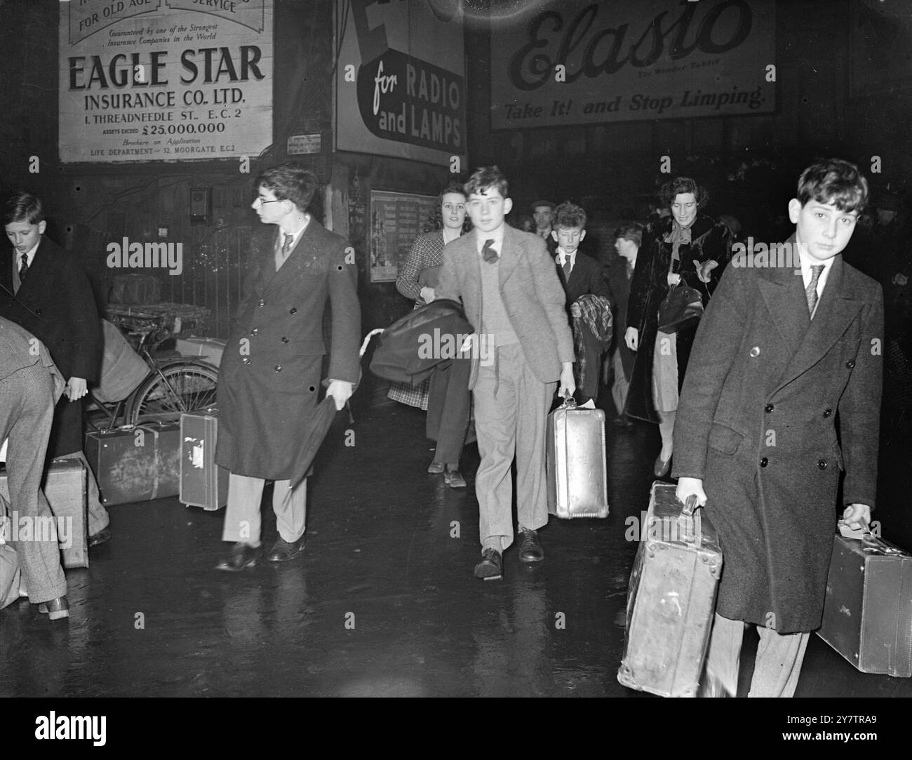 I RAGAZZI DI ETON TORNANO A CASA PER LE VACANZE DI NATALE Un treno speciale della mattina presto porta i ragazzi di Eton a Paddington Station, Londra, mentre la scuola si rompe per le vacanze di Natale. I ragazzi gestiscono i loro bagagli mentre cambiano treno nella stazione affollata. Ragazzi e ragazze di quasi 100 scuole arrivano lì con treni ordinari e speciali, al culmine della corsa. Foto Shwos: I ragazzi di Eton arrivano alla stazione di Paddington, Londra, portando con sé i loro bagagli, che partono per le vacanze di Natale. 19 dicembre 1945 Foto Stock