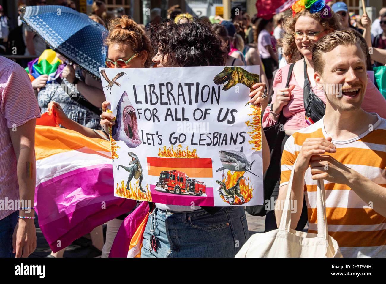 Liberazione per tutti noi. Andiamo lesbiche. Donna con un cartello in carta alla parata Helsinki Pride 2024 a Mannerheimintie a Helsinki, Finlandia. Foto Stock