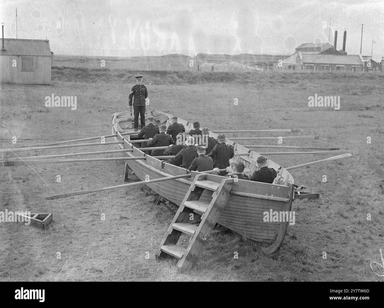 ADDESTRARE GLI "ALL ROUNDERS" DELLE FORZE BRITANNICHE non ha praticamente alcun lavoro in tempo di guerra che non sia svolto dai membri dei Royal Marines, probabilmente la forza più versatile del Regno Unito. I Royal Marines prestano servizio sulle navi ando n shore in tutto il mondo. Gli uomini sono addestrati in molti tipi di artiglieria, nell'uso di proiettori, in tutte le forme di segnali, nel lavoro di fanteria e anche come piloti per il Fleet Air Arm. Queste foto sono state scattate presso il deposito di addestramento dei Royal Marines in un porto nel sud dell'Inghilterra, dove molte giovani reclute stanno ora imparando i vari compiti del reggimento. Spettacoli fotografici: Boat Dril Foto Stock