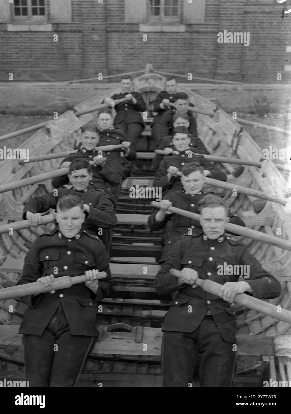 ADDESTRARE GLI "ALL ROUNDERS" DELLE FORZE BRITANNICHE non ha praticamente alcun lavoro in tempo di guerra che non sia svolto dai membri dei Royal Marines, probabilmente la forza più versatile del Regno Unito. I Royal Marines prestano servizio sulle navi ando n shore in tutto il mondo. Gli uomini sono addestrati in molti tipi di artiglieria, nell'uso di proiettori, in tutte le forme di segnali, nel lavoro di fanteria e anche come piloti per il Fleet Air Arm. Queste foto sono state scattate presso il deposito di addestramento dei Royal Marines in un porto nel sud dell'Inghilterra, dove molte giovani reclute stanno ora imparando i vari compiti del reggimento. La foto mostra: "Tirare Foto Stock