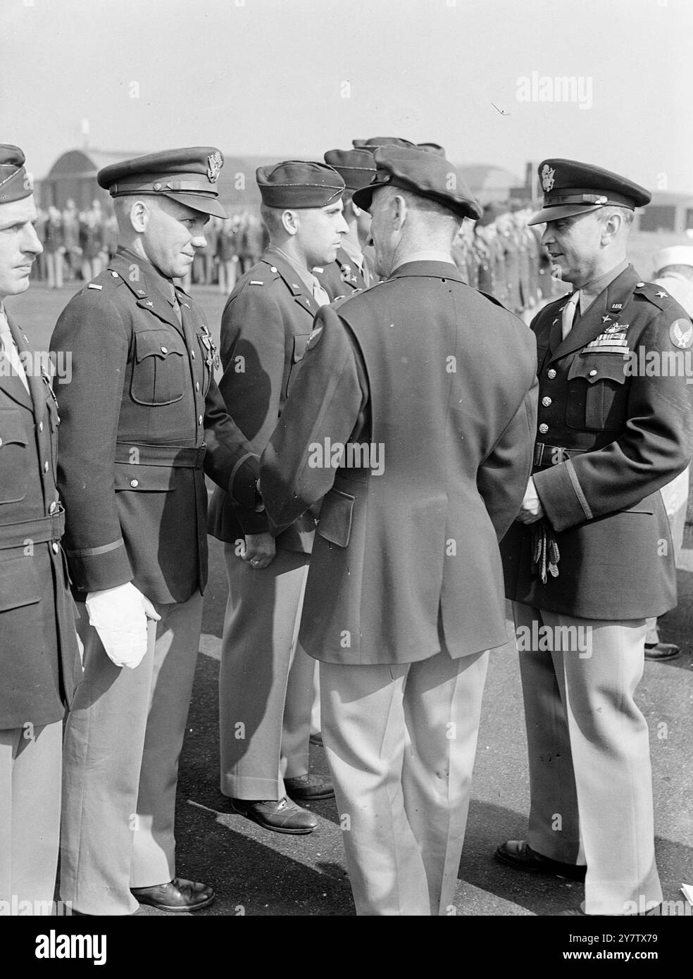 EROI DELL'AERONAUTICA MILITARE STATUNITENSE DECORATI IN INGHILTERRA. Il maggior generale Carl Spaatz, comandante dell'US Army Air Force nel teatro europeo delle operazioni, visitò una stazione operativa in Inghilterra, presentando premi a ventitré ufficiali e uomini per il distinto servizio durante le operazioni sul territorio occupato nemico. Spettacoli fotografici: Il maggiore generale Spaatz stringe la mano al primo tenente Richard F Starks, di Midway, Kentucky, il tenente Starks è stato ferito mentre pilotava un bombardiere durante un attacco ai Paesi Bassi, e ha ricevuto due decorazioni, il DSC americano e l'ordine del cuore viola. 1 Foto Stock