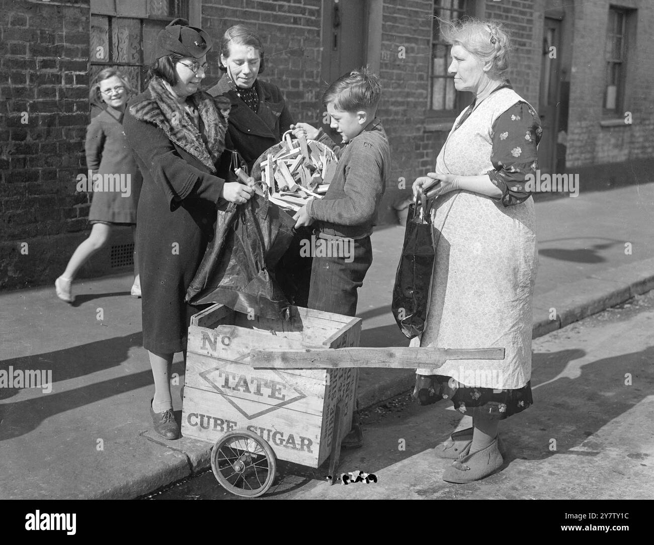 LAMBETH, 11 ANNI, VENDE LEGNA DA ARDERE DA CASE BOMBARDATE PER LA SETTIMANA DELLE ARMI DA GUERRA DI LONDRA. Ho già mandato una sterlina e dieci scellini come regalo al suo sindaco. Ronald Spanner, 11 anni di vita presbiteriana, ragazzo di Lambeth, passa il suo tempo libero a raccogliere fondi per la settimana delle armi di guerra di londra e per qualsiasi altra buona causa. Ronald, il cui padre è un vetraio e che ha due fratelli nell'esercito, ha avuto l'idea di raccogliere legna da case bombardate, tagliarla e venderla come legna da ardere ai suoi vicini a due passi per raccogliere fondi. Il suo amico, Dennis Emms di 12 anni, lo aiutava, ma blas Foto Stock