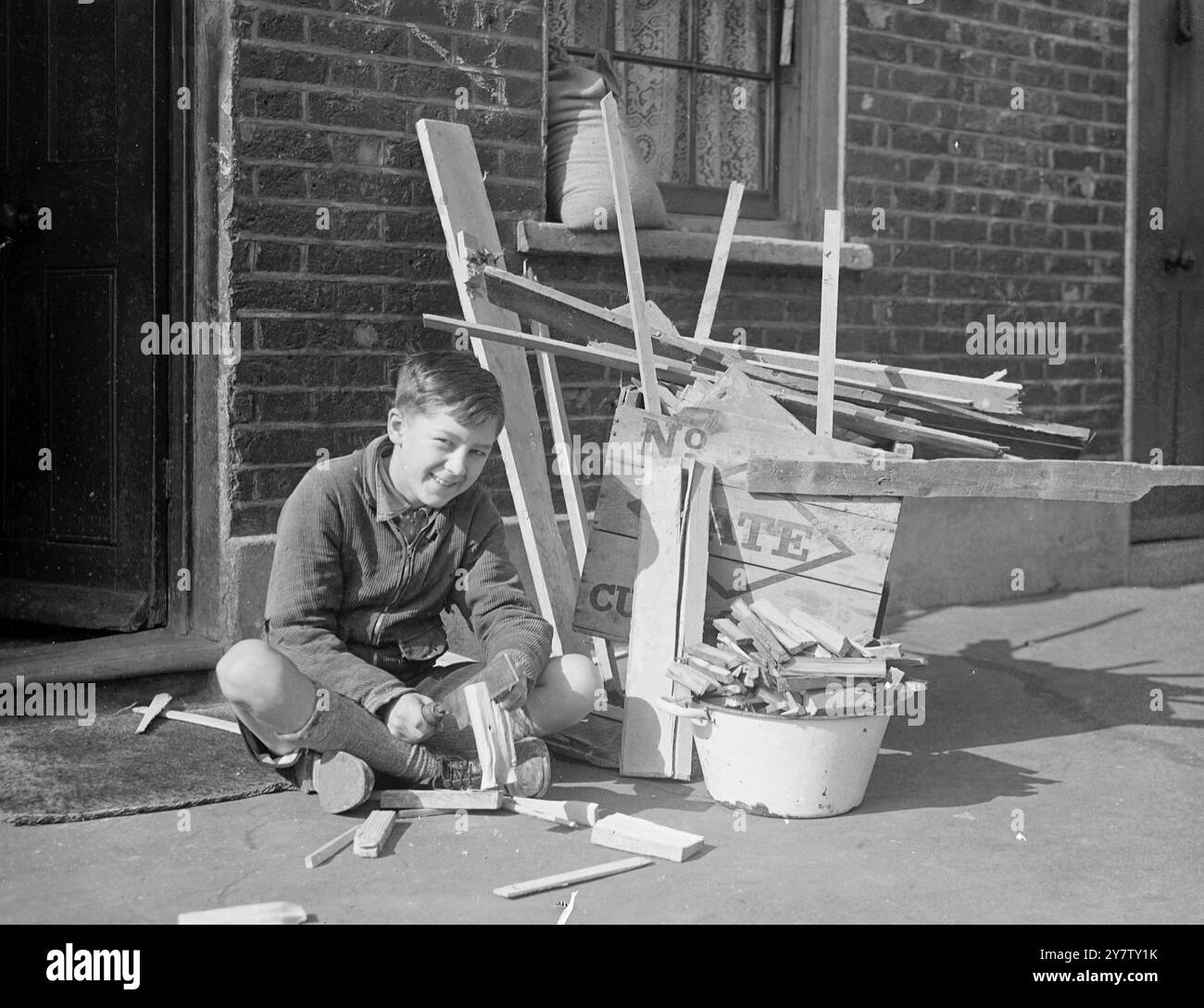 LAMBETH, 11 ANNI, VENDE LEGNA DA ARDERE DA CASE BOMBARDATE PER LA SETTIMANA DELLE ARMI DA GUERRA DI LONDRA. Ho già mandato una sterlina e dieci scellini come regalo al suo sindaco. Ronald Spanner, 11 anni di vita presbiteriana, ragazzo di Lambeth, passa il suo tempo libero a raccogliere fondi per la settimana delle armi di guerra di londra e per qualsiasi altra buona causa. Ronald, il cui padre è un vetraio e che ha due fratelli nell'esercito, ha avuto l'idea di raccogliere legna da case bombardate, tagliarla e venderla come legna da ardere ai suoi vicini a due passi per raccogliere fondi. Il suo amico, Dennis Emms di 12 anni, lo aiutava, ma blas Foto Stock