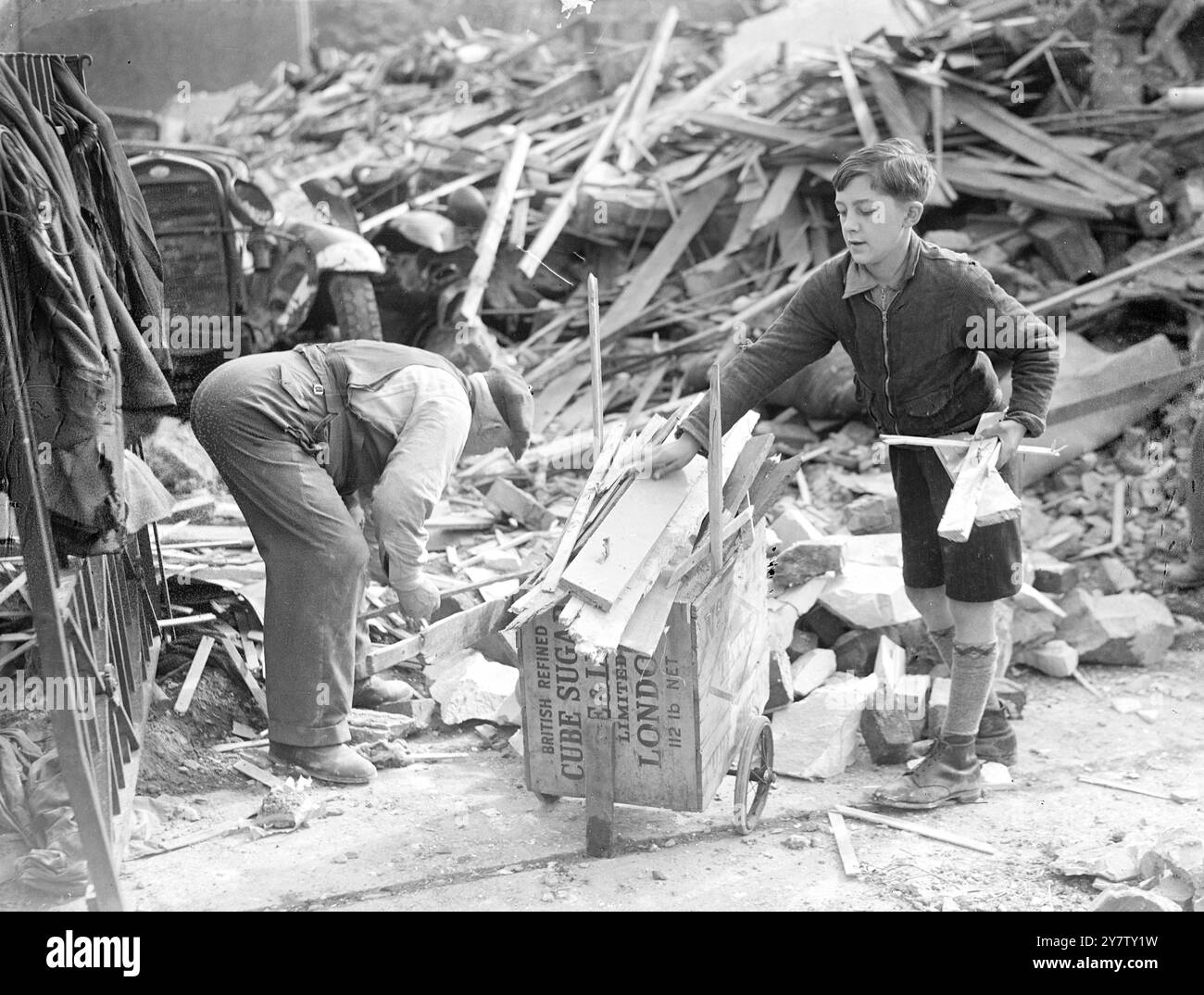 IL RAGAZZO DI 11 ANNI LAMBETH VENDE LEGNA DA ARDERE DA CASE BOMBARDATE PER LA SETTIMANA DELLE ARMI DA GUERRA DI LONDRA. Ho già mandato una sterlina e dieci scellini come regalo al suo sindaco. Ronald Spanner, 11 anni di vita presbiteriana, ragazzo di Lambeth, passa il suo tempo libero a raccogliere fondi per la settimana delle armi di guerra di londra e per qualsiasi altra buona causa. Ronald, il cui padre è un vetraio e che ha due fratelli nell'esercito, ha avuto l'idea di raccogliere legna da case bombardate, tagliarla e venderla come legna da ardere ai suoi vicini a due passi per raccogliere fondi. Il suo amico, Dennis Emms, dodicenne, doveva aiutarlo, ma... cavolo Foto Stock