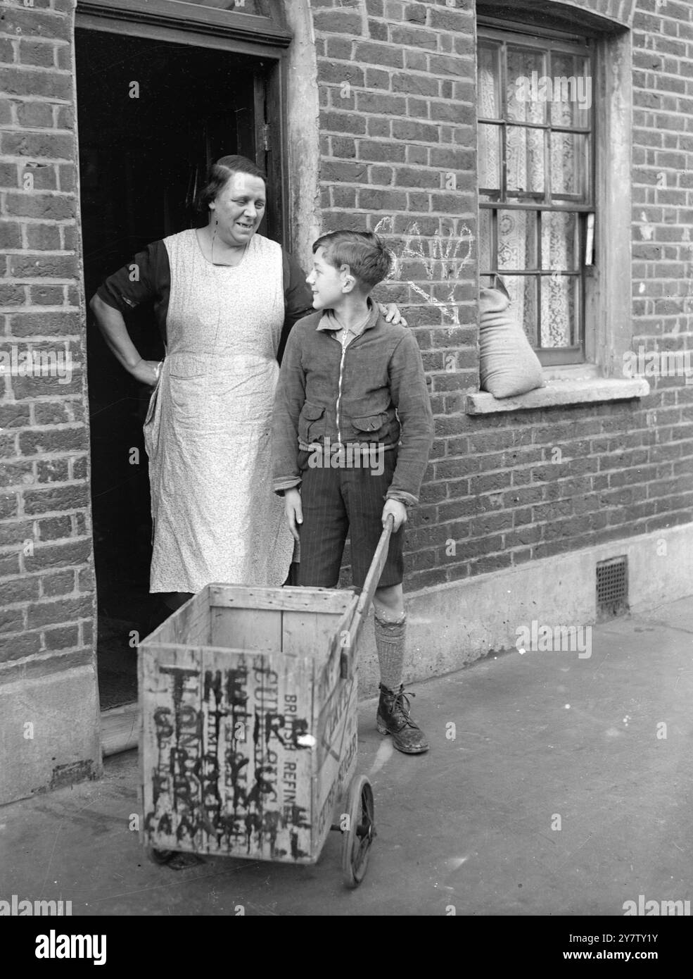IL RAGAZZO DI 11 ANNI LAMBETH VENDE LEGNA DA ARDERE DA CASE BOMBARDATE PER LA SETTIMANA DELLE ARMI DA GUERRA DI LONDRA. Ho già mandato una sterlina e dieci scellini come regalo al suo sindaco. Ronald Spanner, 11 anni di vita presbiteriana, ragazzo di Lambeth, passa il suo tempo libero a raccogliere fondi per la settimana delle armi di guerra di londra e per qualsiasi altra buona causa. Ronald, il cui padre è un vetraio e che ha due fratelli nell'esercito, ha avuto l'idea di raccogliere legna da case bombardate, tagliarla e venderla come legna da ardere ai suoi vicini a due passi per raccogliere fondi. Il suo amico, Dennis Emms, dodicenne, doveva aiutarlo, ma... cavolo Foto Stock