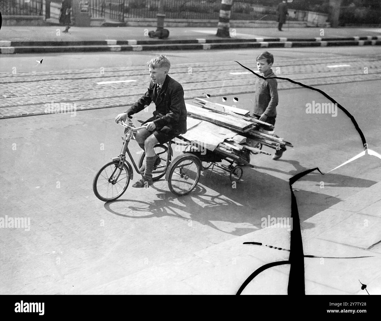 IL LEGNO È IL LORO CONTRIBUTO foto: Raccogliere legna da ardere nell'ultimo tipo di veicolo - questi due ragazzi di Camberwell, Londra, stanno raccogliendo legna da case bombardate e la portano in discarica su un ciclo fatato e su un rimorchio attaccato. 29 maggio 1941 Foto Stock