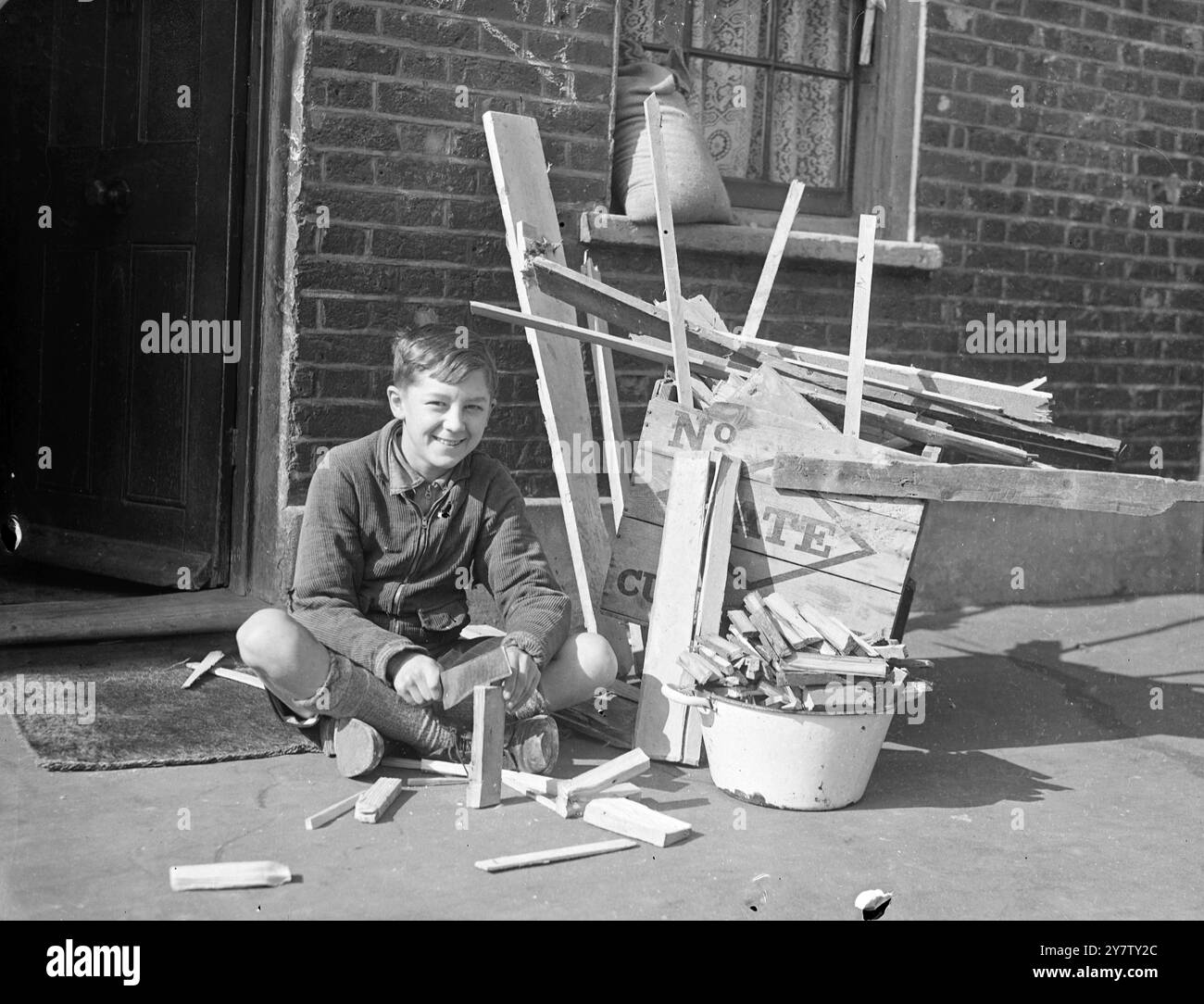 IL RAGAZZO DI 11 ANNI LAMBETH VENDE LEGNA DA ARDERE DA CASE BOMBARDATE PER LA SETTIMANA DELLE ARMI DA GUERRA DI LONDRA. Ho già mandato una sterlina e dieci scellini come regalo al suo sindaco. Ronald Spanner, 11 anni di vita presbiteriana, ragazzo di Lambeth, passa il suo tempo libero a raccogliere fondi per la settimana delle armi di guerra di londra e per qualsiasi altra buona causa. Ronald, il cui padre è un vetraio e che ha due borhter nell'esercito, ha avuto l'idea di raccogliere legna da case bombardate, tagliarla e venderla come legna da ardere ai suoi vicini a due passi per raccogliere fondi. Il suo amico, Dennis Emms, dodicenne, doveva aiutarlo, ma... cavolo Foto Stock
