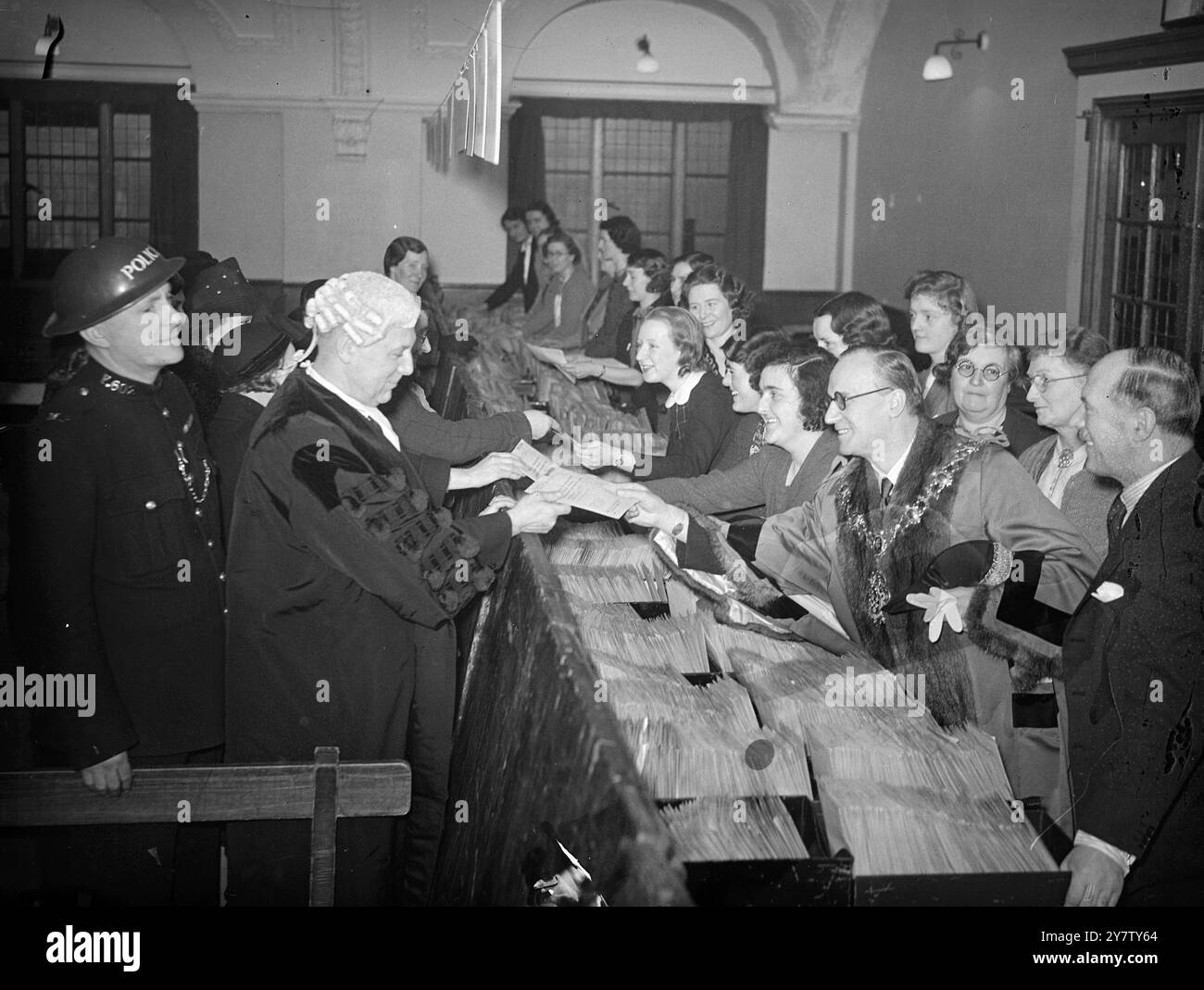 I LONDINESI DIVIDONO 60 MILA Sterline Una quota di 60 mila sterline fu fatta ad Hammersmith dal sindaco, consigliere R H Kent JP che distribuì i pacchetti ai suoi predecessori e ad altri Aldermen che erano membri della società. La società è la Broadway Congregational Friendly Society. Spettacoli fotografici: Il sindaco di Hammersmith Richard Kent consegna una quota al consigliere comunale Hugh Royle, 19 dicembre 1940 Foto Stock