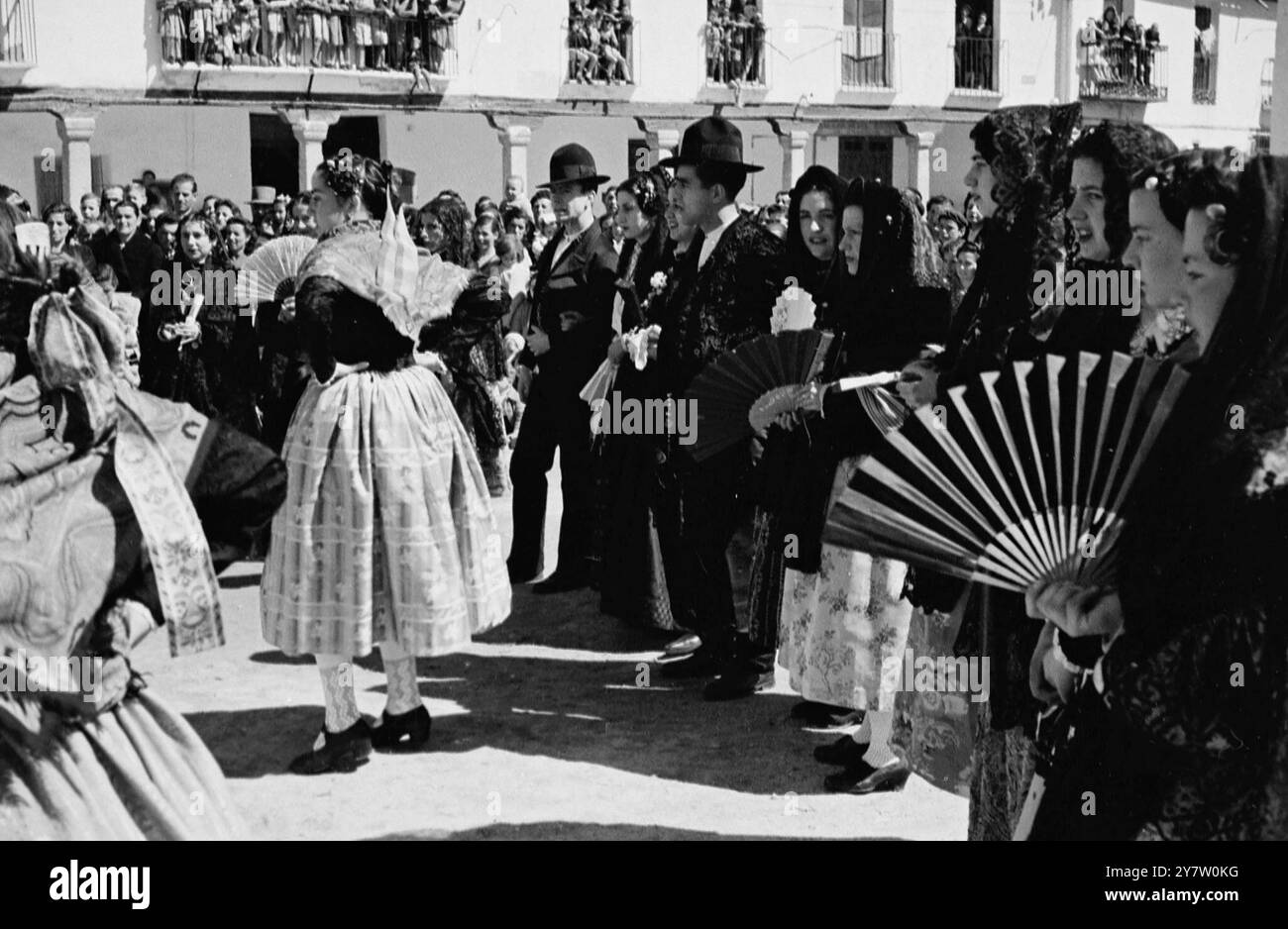 Un MATRIMONIO DI CAMPAGNA IN SPAGNA È Un AFFARE GAY - - vecchi costumi, costumi tradizionali e balli popolari sono la regola di un matrimonio di villaggio in Spagna. Queste foto mostrano un tipico matrimonio a Navalcarnero, nella provincia di Madrid, dove gli sposi e tutti coloro che partecipano indossano i colorati costumi della vecchia Spagna, e tutta la gente di campagna si affollano nella piazza del villaggio, per guardare le vecchie danze popolari o per prendere parte alla gaiety stessa. - Spettacoli fotografici: La sposa e lo sposo guardano le danze della vecchia campagna nella piazza del paese, lo sposo indossa una giacca intelligente bolero di pelliccia e il br Foto Stock