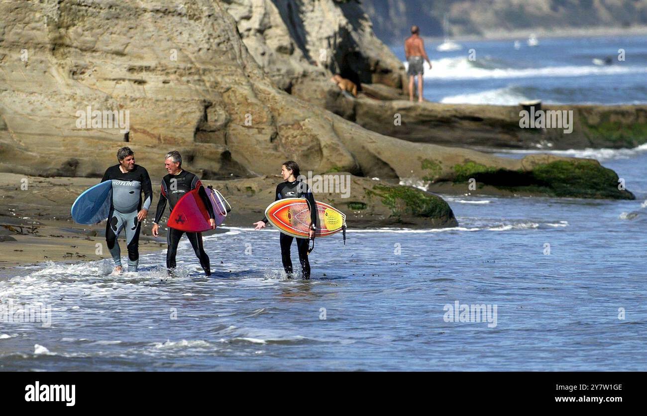 Santa Cruz, California: Surfisti femminili e maschili tornano a casa dopo aver cavalcato le onde. Il surf, un tempo sport dominato dagli uomini, ha guadagnato popolarità tra le donne nel corso degli anni, e di recente con il film "Blue Crush", una storia di ragazze surfiste ambientate alle Hawaii. 1° ottobre 2002 Foto Stock