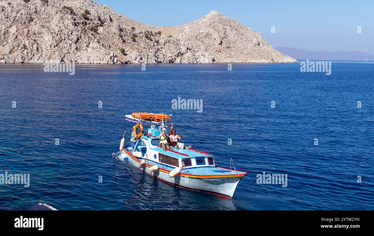 Barca nella baia di San Giorgio nelle isole greche di Simi in Grecia Foto Stock