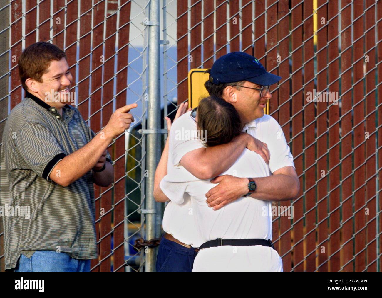 Oakland, California: I dipendenti del magazzino di Oakland Webvan.com (L-R) Mario Vargar, guardano Mark E. Weber abbracciare Debra Bartunek dopo essersi presentati per il loro turno di PM per trovare i cancelli chiusi lunedì 9 luglio 2001 dopo la chiusura di Webvan Group Inc. E archiviare il capitolo 11 della bancarotta. Duemila dipendenti perderanno il lavoro con il droghiere online Webvan Group Inc. Foto Stock