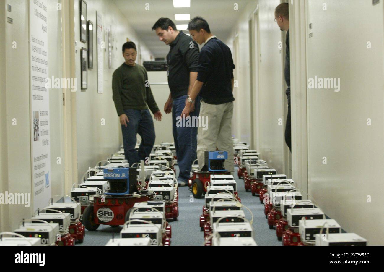 Menlo Park, California, vicino a 100 robot Centibot allineano il corridoio di SRI International venerdì 19 dicembre 2003. I Centibot fanno parte di un progetto militare finanziato dalla Defense Advanced Research Project Agency del Pentagono. Centobot può lavorare insieme come un team, adattandosi al cambiamento delle circostanze. Possono far fronte a eventi imprevisti e affrontare l'incertezza inerente al rilevamento e all'azione sul mondo fisico. Foto Stock