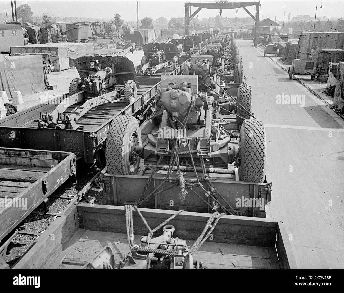 REGNO UNITO L'ARSENALE DI INVASIONE la Gran Bretagna è un enorme arsenale per la più grande operazione combinata della storia, l'invasione dell'Europa di Hitler. Tutto ciò che serve a rendere l'esercito moderno è ammassato in discariche e negozi in tutta la campagna. Spettacoli fotografici: Treni carichi di supporti Howitzer (a destra) e cannoni anticarro da qualche parte è l'Inghilterra. 22 maggio 1944 Foto Stock