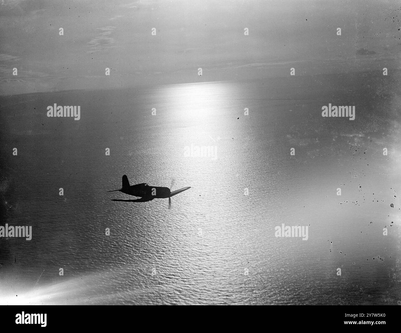Spettacoli fotografici di PATTUGLIA AL TRAMONTO: Un caccia a lungo raggio Corsair da sei cannoni ritorna alla portaerei di scorta HMS Ravager dopo una pattuglia al tramonto. L'aereo statunitense Vought Sikorsky è l'ultima aggiunta alla potenza impressionante della Fleet Air Arm, e faceva parte della scorta quando Barracudas ha fatto esplodere la corazzata tedesca Tirpitz da 45.000 tonnellate. Aprile 1944 Foto Stock