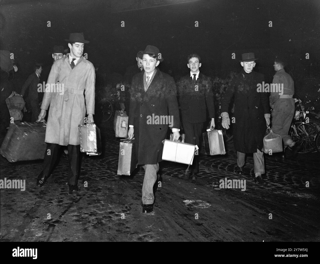I RAGAZZI DI ETON TORNANO A CASA PER LE VACANZE DI NATALE Un treno speciale della mattina presto porta i ragazzi di Eton a Paddington Station, Londra, mentre la scuola si rompe per le vacanze di Natale. I ragazzi gestiscono i loro bagagli mentre cambiano treno nella stazione affollata. Ragazzi e ragazze di quasi 100 scuole arrivano lì con treni ordinari e speciali, al culmine della corsa. Foto Shwos: I ragazzi di Eton arrivano alla stazione di Paddington, Londra, portando con sé i loro bagagli, che partono per le vacanze di Natale. 19 dicembre 1945 Foto Stock