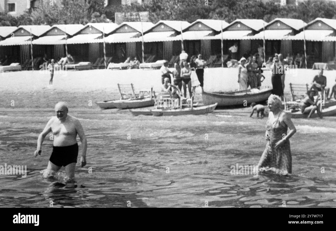 Winston Churchill e sua moglie - che sono in vacanza qui - vanno a nuotare al Lido di Venezia, Venezia, Italia. La signora Churchill indossa un costume a tutta lunghezza, mentre suo marito sfoggia i costumi da bagno rossi. Il signor Churchill obiettò che i fotografi lo prendessero nei suoi tronchi rossi, e che le guardie sequestrassero i loro film. Ad un certo punto l'ex Premier, che ha lasciato la Costa Azzurra perché era troppo rumorosa, ha spruzzato acqua ai cameramen mentre gli si avvicinavano su una barca. 2 settembre 1951 Foto Stock