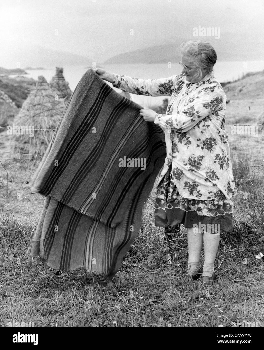 tessitrice ' reale' di Harris - Un tappeto per auto è tenuto in mano dal tessitore - la sig.ra Alex MacDonald , che ha tinto la lana con verdure, ha filato a mano la lana e poi la ha prodotta sul suo telaio per mano. - Novembre 1960 Foto Stock