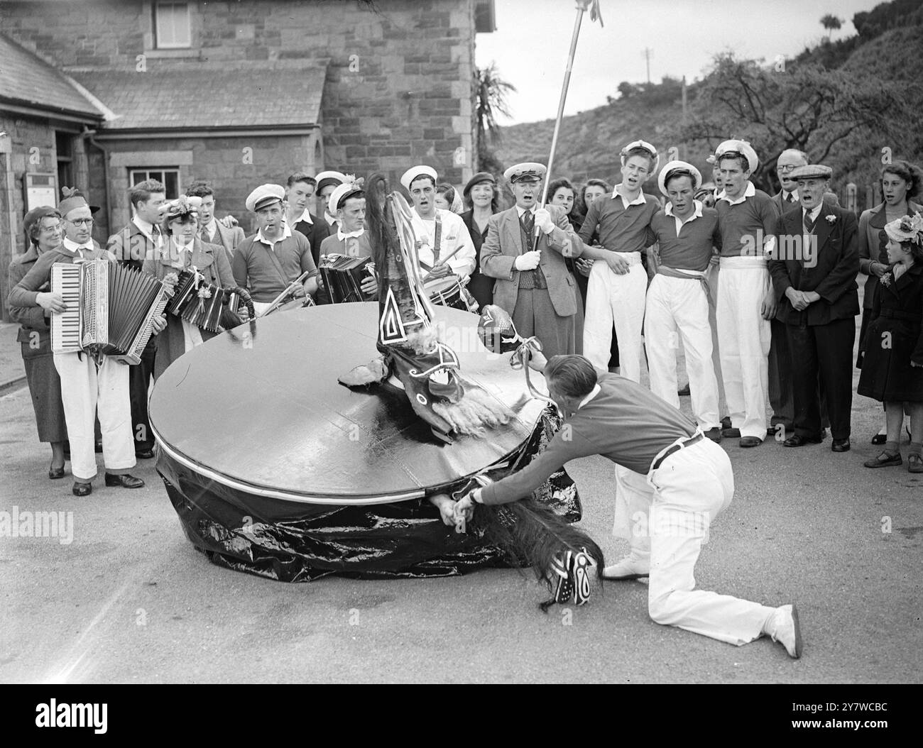 La 'Obby' Oss di Padstow riparte nella parata del giorno di maggio - la tradizionale 'Obby' Oss fu ancora una volta il fulcro della parata annuale del giorno di maggio di Padstow ( North Cornwall ) . Seguiti da balli e canti cittadini e altri che suonano gli accordi , preceduti dal solito teaser con un bastone per infastidirla , l'"Obby" Oss ha scatenato le celebrazioni della giornata. La leggenda dice che questo fantastico cavallo era uno dei tanti che la gente di Padstow usava sfilare sulle cime della scogliera quando fu avvistata l'Armada spagnola. Da lontano, sembrava un esercito a cavallo, e si diceva che l'Armada fosse spaventata Foto Stock