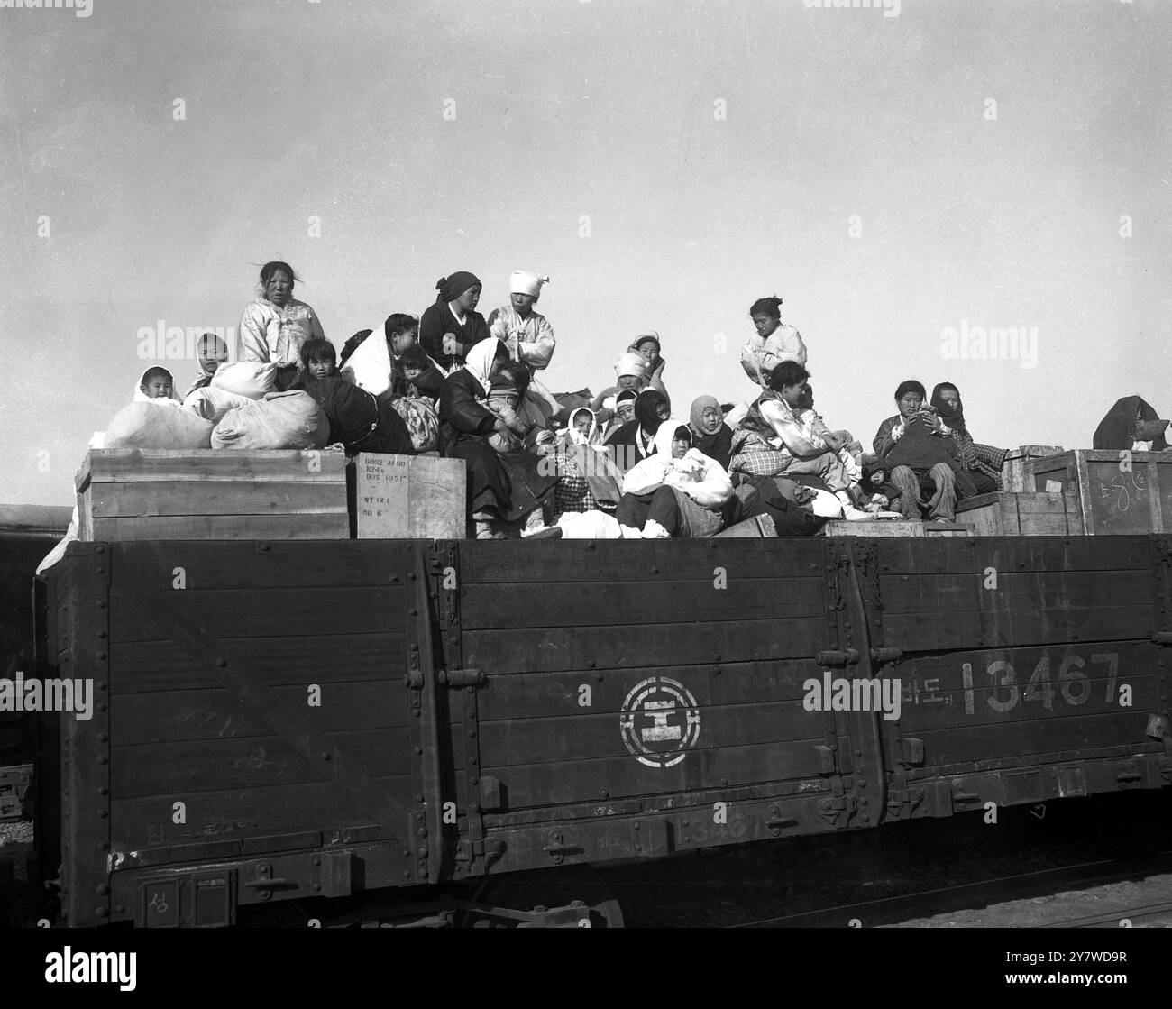 Rifugiati civili nordcoreani , donne e bambini con i loro pochi effetti personali aggrappati nelle loro mani , si mescolano in un tumulto incompleto con attrezzature militari mentre si precipitano per lo spazio su un treno diretto a sud , nel tentativo di sfuggire alle orde in avanzata dei cinesi comunisti . 10 dicembre 1950 Foto Stock