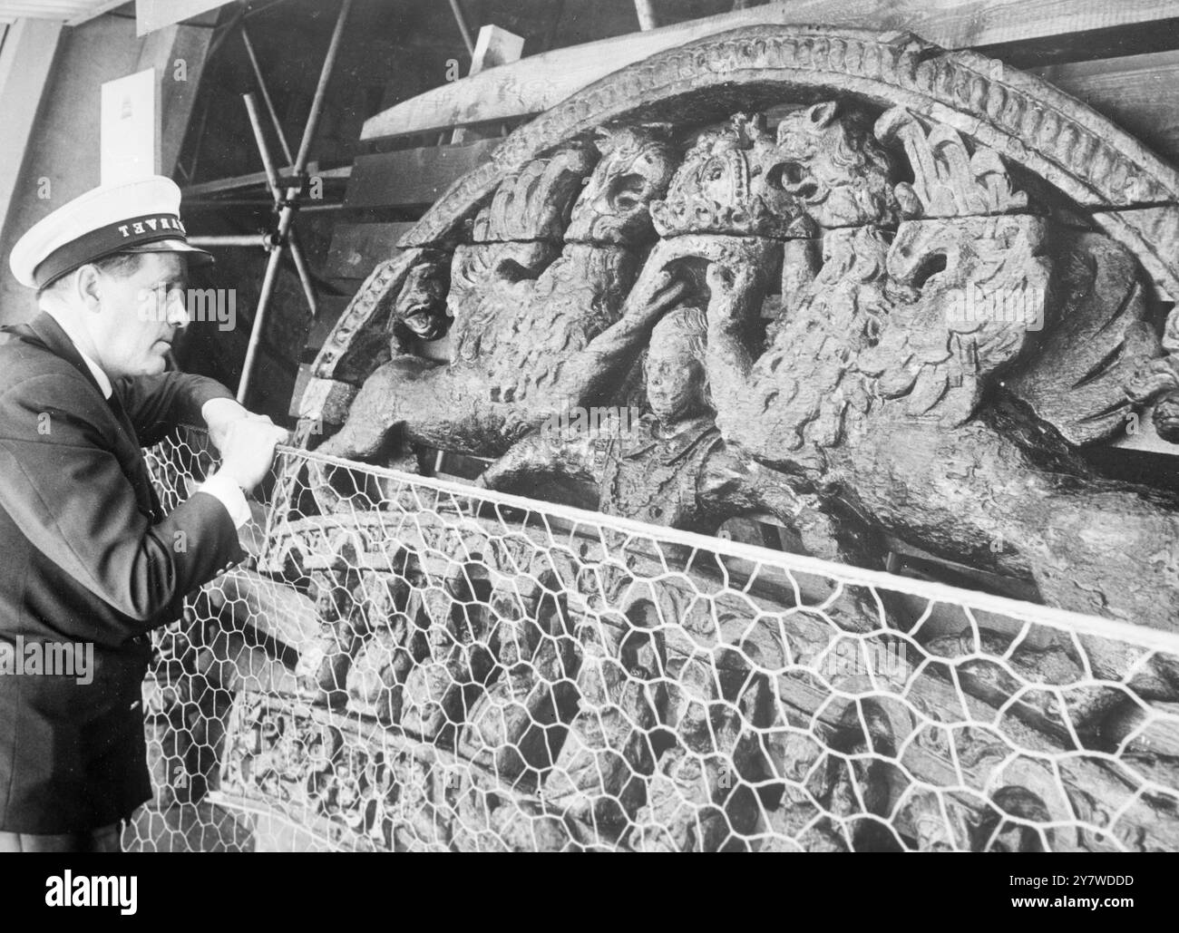 Il gigantesco stemma nazionale svedese, trovato ai piedi del porto di Stoccolma, viene esaminato da una guardia del museo dopo essere stato riassemblato. E' stato trovato in 17 pezzi. Foto Stock