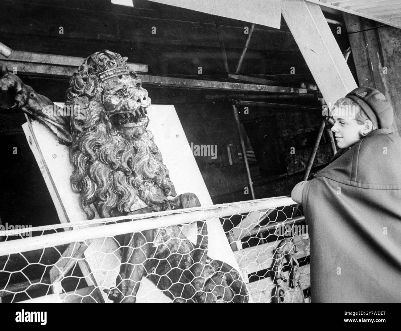Il gigantesco stemma nazionale svedese, trovato ai piedi del porto di Stoccolma, viene esaminato da una guardia del museo dopo essere stato riassemblato. E' stato trovato in 17 pezzi. Foto Stock
