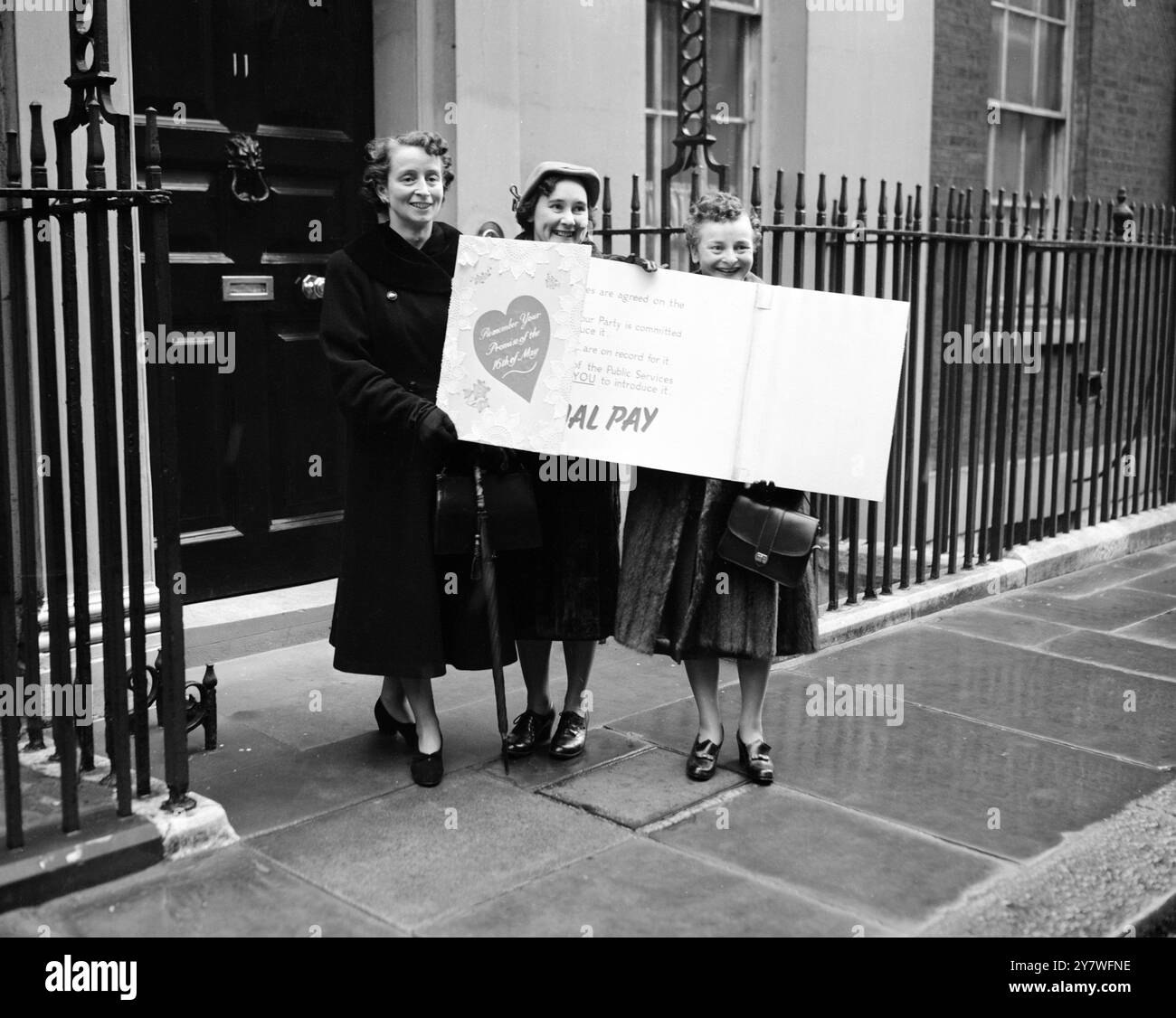 Recanti una tessera di san valentino fuori misura con la scritta "ricordate la vostra promessa del 16 maggio - siate fedeli a noi il giorno del bilancio", tre donne del Comitato EQUAL Pay del servizio pubblico arrivano all'11 di Downing Street per presentare la tessera al Cancelliere dello Scacchiere, signor R A Butler. Le donne sono da sinistra a destra, la signora Wyn Kidd, la signora Murile Coult e la signora Doris Lancaster. 14 febbraio 1953 Foto Stock
