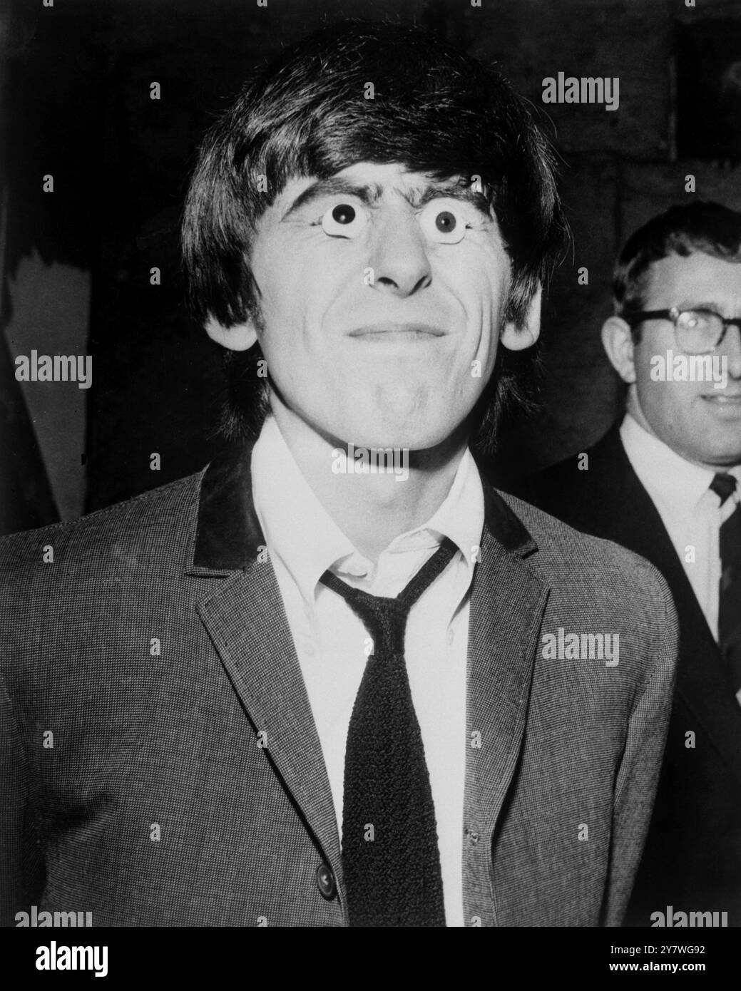 Beatle George Harrison con Beatle Eyes durante le riprese agli Shepperton Studios il 12 marzo 1964 Foto Stock