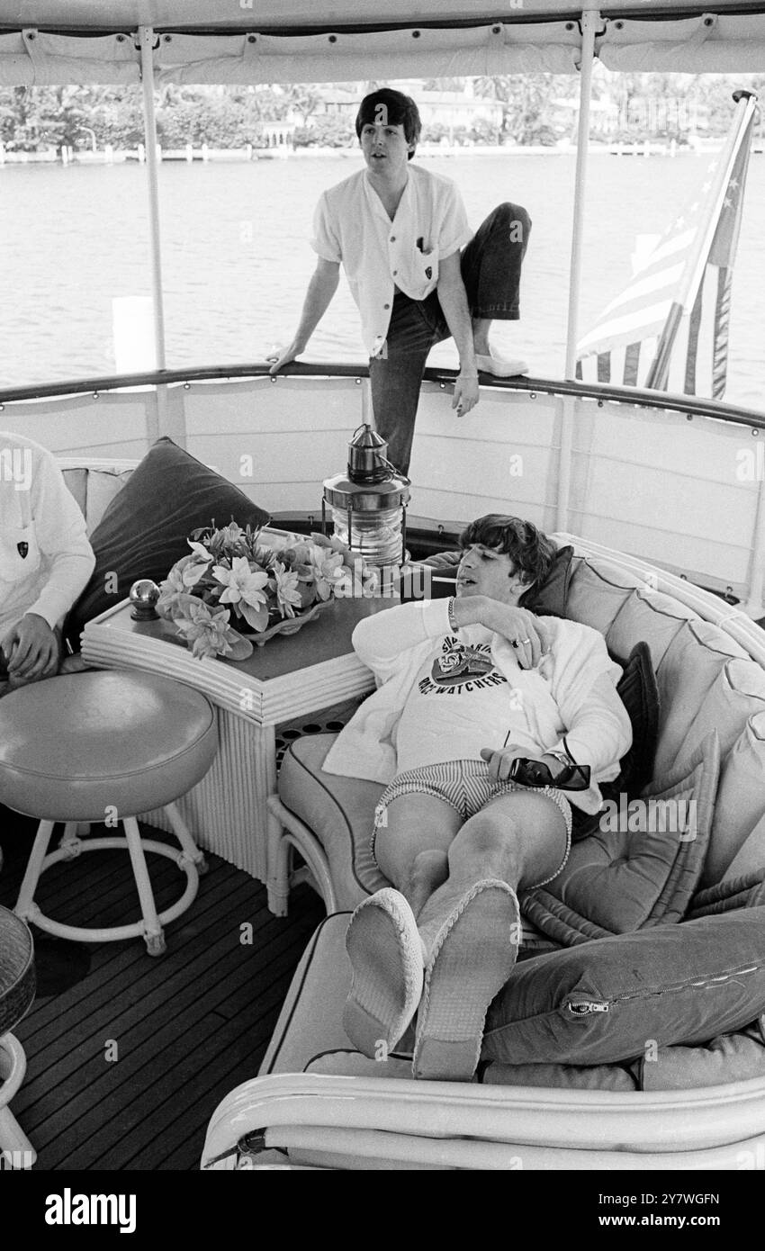 I Beatles , prima di partire da Miami per un viaggio in yachting . Ringo Starr si rilassa su un divano con Paul McCartney sullo sfondo. 17 febbraio 1964 Foto Stock