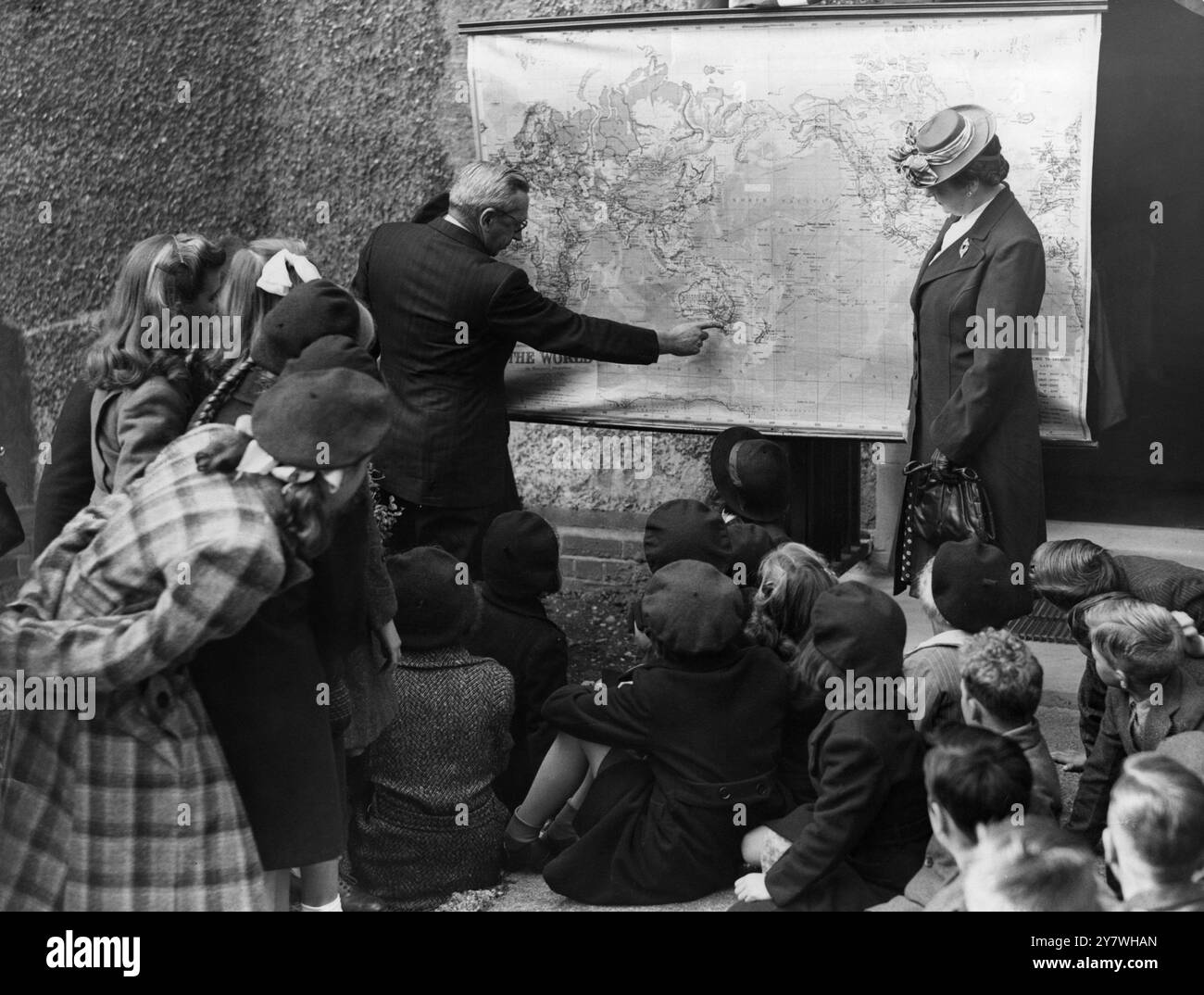 In partenza per l' Australia sulla SS Ormonde , la prima nave di linea ad essere riservata esclusivamente al traffico di migranti diretti in Australia , vi sono quaranta ragazzi e ragazze del dottor Barnardo's Garden City , Woodford Bridge , Essex . La festa di venti ragazzi e due ragazze è la prima a lasciare il dottor Barnardo per una nuova vita da prima della guerra. I ragazzi devono andare in una scuola di agricoltura nel nuovo Galles del Sud; le ragazze in una casa di formazione di servizio domestico vicino a Sydney. Immagini: Norman Michell CBE , Vice alto Commissario per l'Australia, spiega il percorso verso l'Australia ad alcuni dei bambini emigrati a Foto Stock