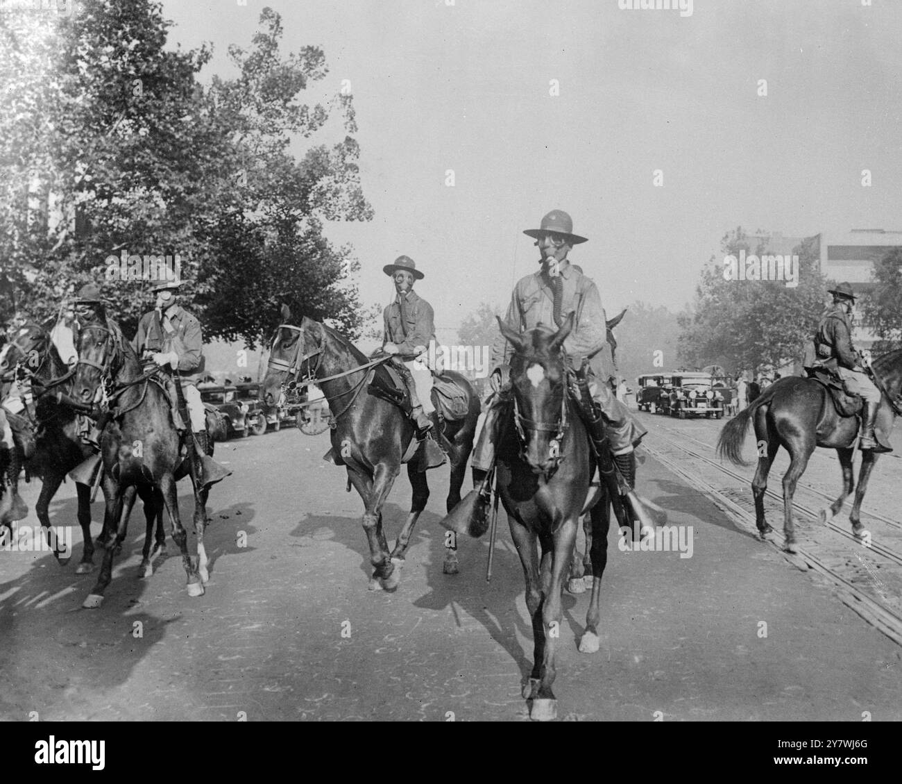Le truppe federali sconfissero completamente ottomila manifestanti dell' Esercito Bonus accamparsi in un parco aperto fuori Washington e bruciarono il loro campo di baracche di legno al suolo, quando rifiutarono di andarsene quando richiesto dal governo. I cavalieri in gas Masks avanzano lungo Pennsylvania Avenue Washington durante i combattimenti. 5 agosto 1932 Foto Stock