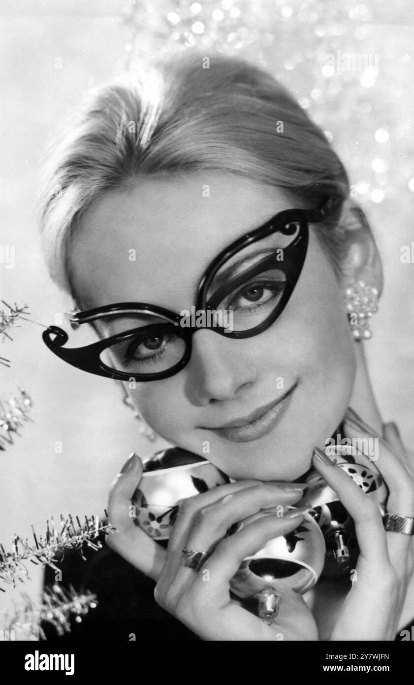 Occhiali con ali di farfalla per farti stare nel giusto stato d'animo per Natale . Roslind Watkins modella gli occhiali , che sono in blu mezzanotte per abbinarsi ai suoi occhi 3 dicembre 1959 Foto Stock
