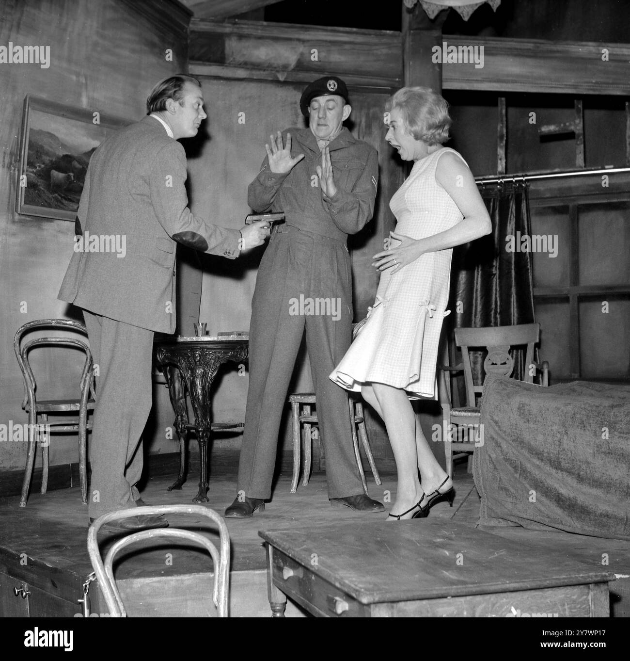 Non c'è modo migliore per ottenere il silenzio totale in un argomento che sbattere fuori una pistola automatica e brandirla furiosamente. In questa scena del nuovo dramma The Game AS Played , di Leon Griffiths , che apre al New Arts Theatre Club di Londra , domani , Denholm Elliott nel ruolo di Crystal - un doppio agente , Petrifies Bettina Dickson che interpreta Mrs Skinner e Bryan Pringle nel ruolo del caporale Skinner , ricomincia dall' orrore . 13 aprile 1965 Foto Stock