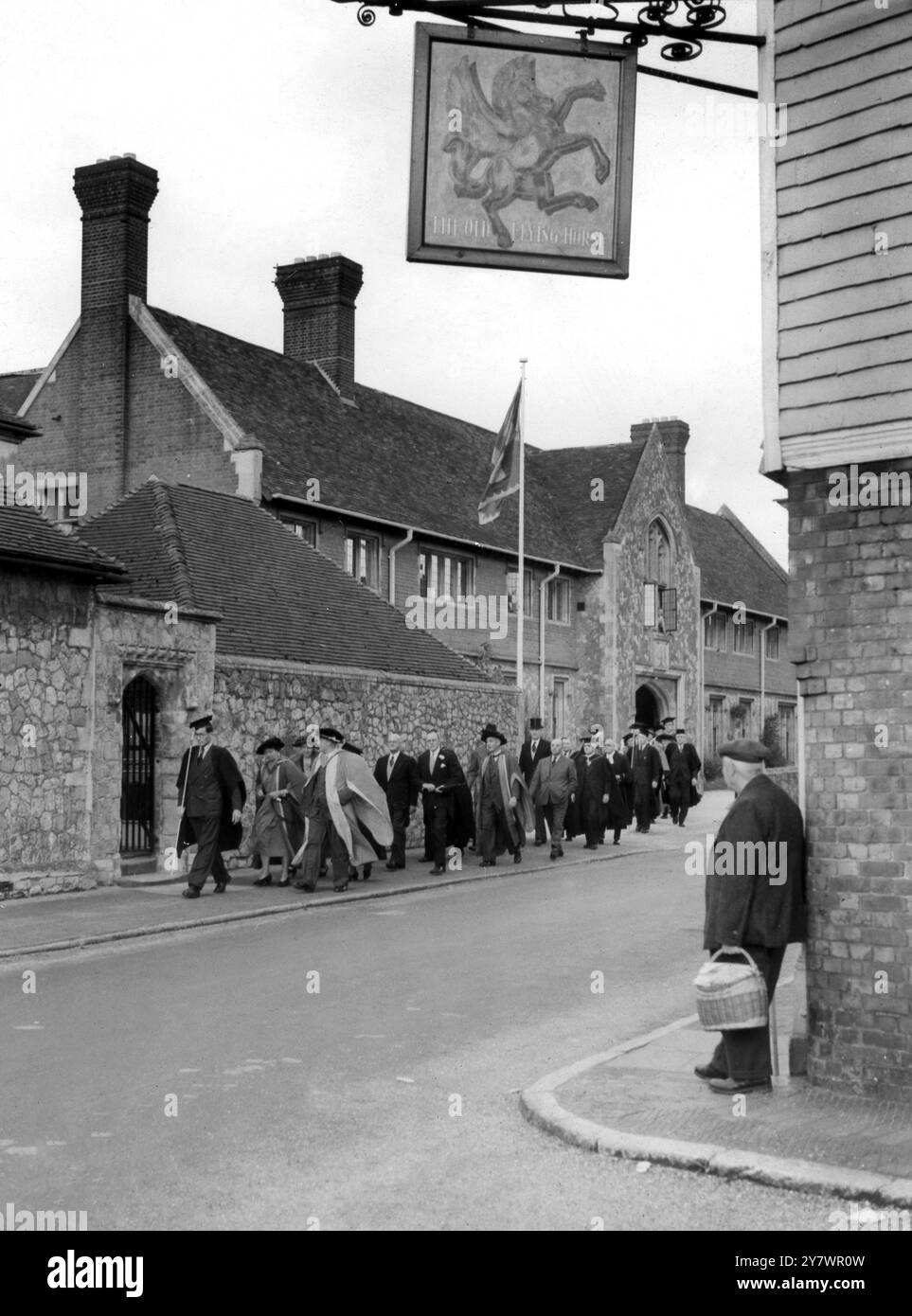 The Old Flying Horse Inn at Broughton Aluph in Ashford , Kent - risale al 1400 quando produceva birra per i pellegrini a Canterbury - il quadro mostra professori universitari nei loro abiti e mortai in processione di fronte al pub ©TopFoto Foto Stock