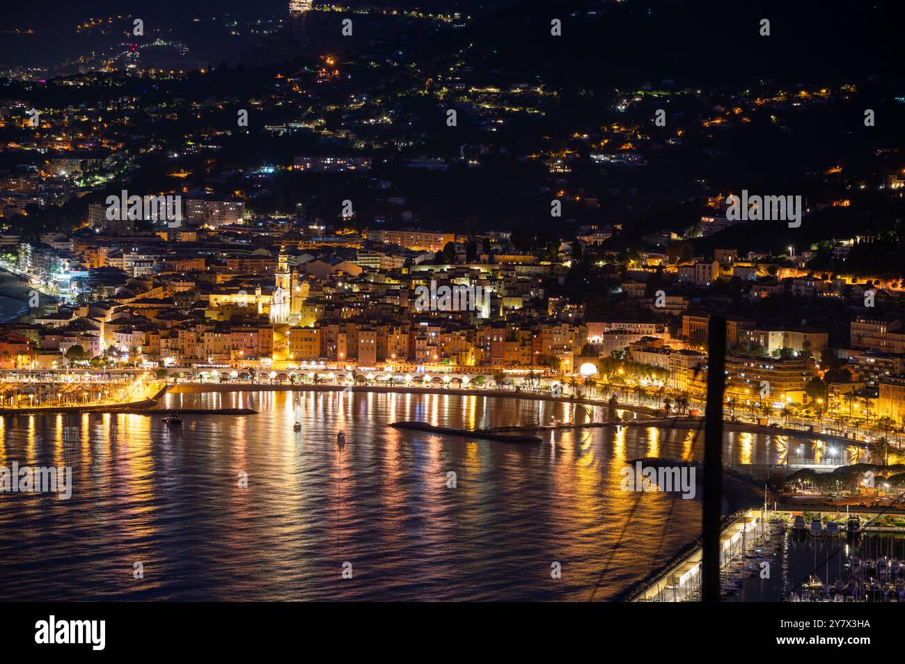 Vista notturna sulla Costa Azzurra, luci della città vecchia di Mentone e porticciolo sul blu del Mar Mediterraneo vicino al confine italo-francese, Monaco, Monte Carlo, viaggio d Foto Stock