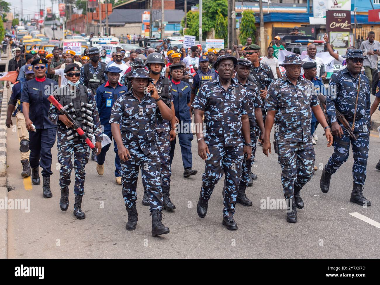 Gli agenti del comando di polizia di Stato di Lagos camminano davanti ai manifestanti a Lagos martedì 1 ottobre 2024. I nigeriani sono fuori il giorno dell'indipendenza per le pubbliche relazioni Foto Stock
