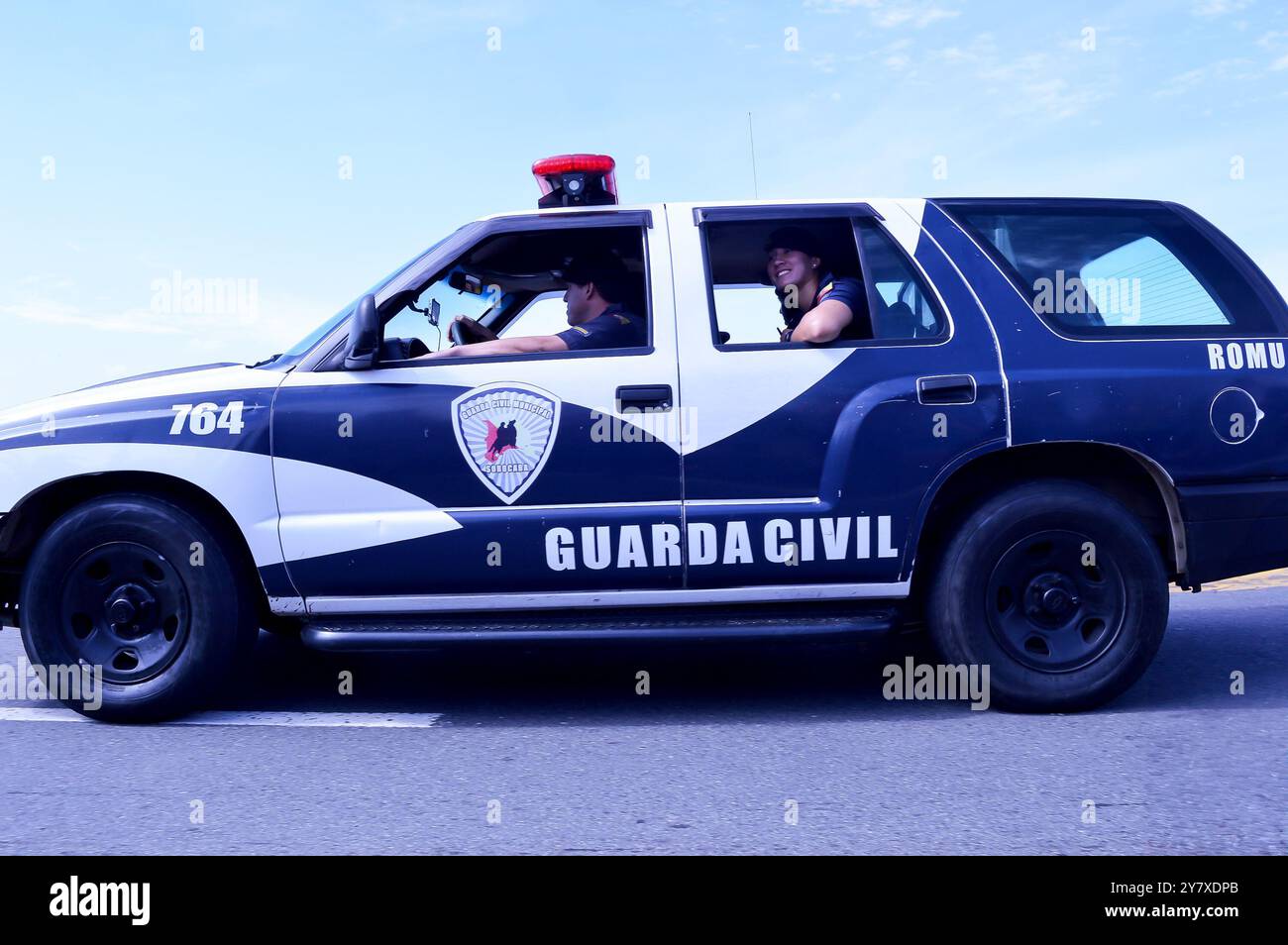 Veicolo della Guardia civile che guida lungo una strada nella città di Sorocaba in Brasile, sul sedile posteriore c'è una guardia femminile che sorride Foto Stock