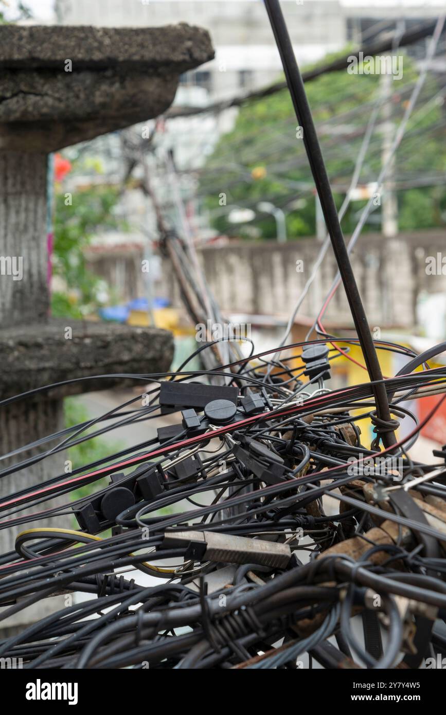 Guardando dall'alto, si trova al primo piano e all'angolo della strada. Molti cavi metallici complessi e frastagliati che corrono lungo le strade laterali in un sobborgo della Foto Stock